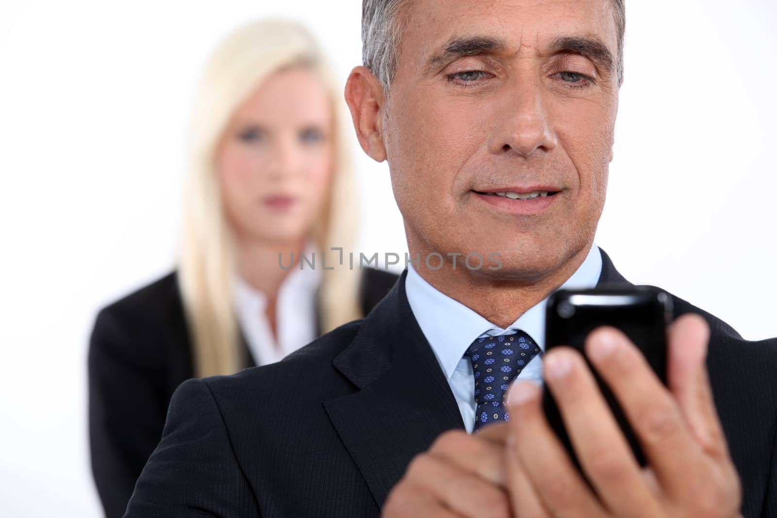 Closeup of a senior businessman using mobile phone by phovoir