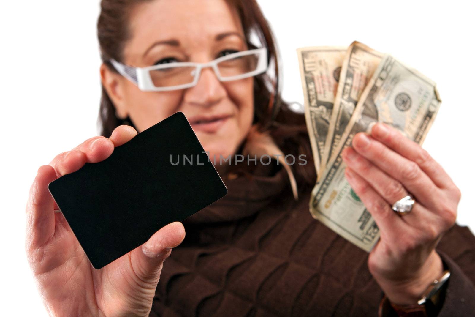 Middle aged woman carefully trying to decide between using old fashioned cash or a plastic credit card.