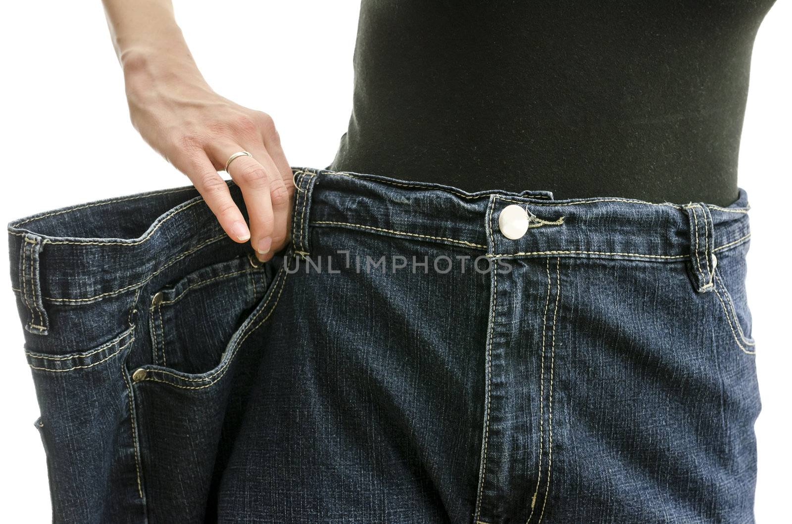 Closeup of a slim woman waist in oversized pants after losing a lot of weight. Over white background.