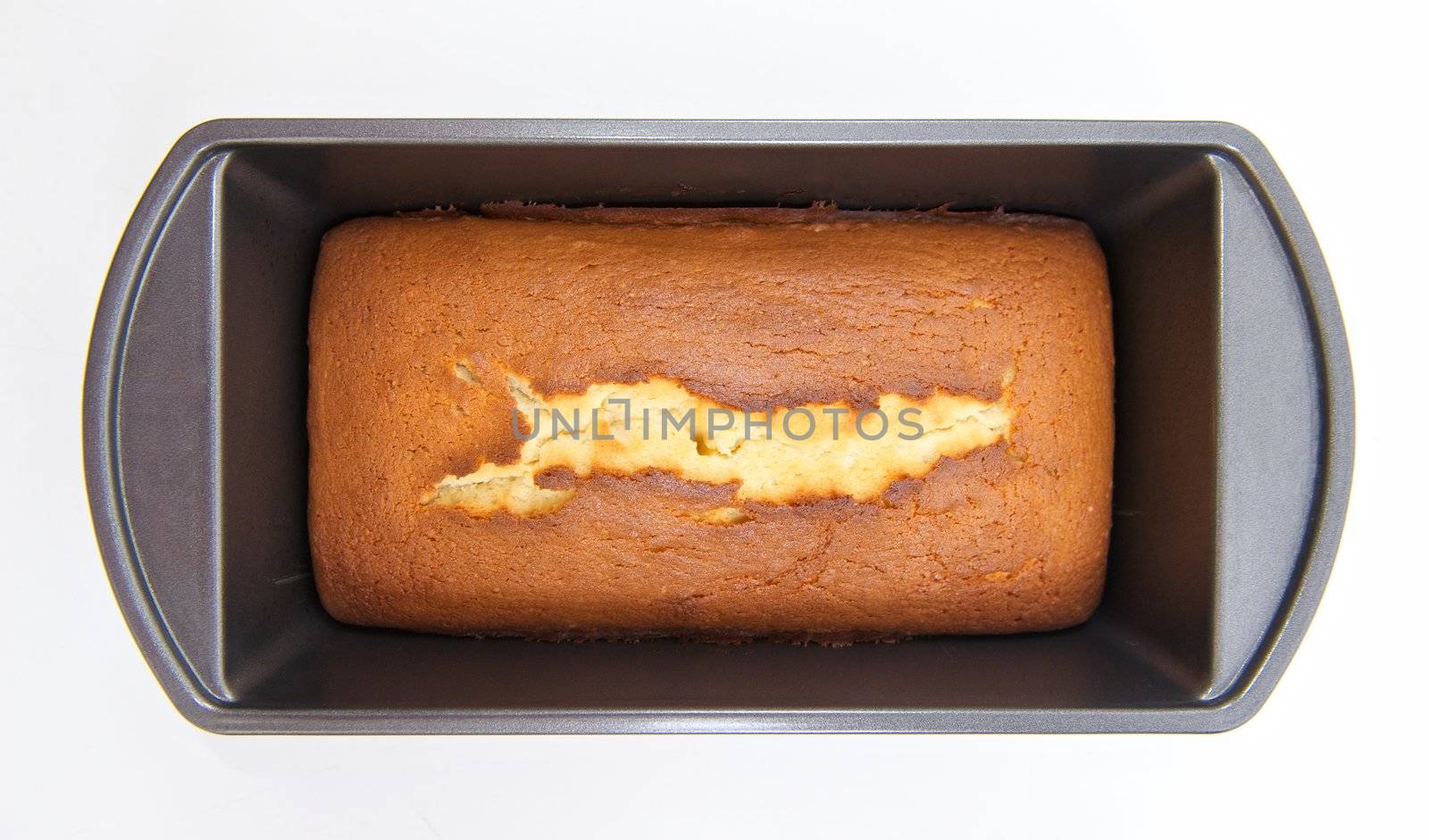 Homemade pound cake baked in an old fashioned bread tray or mold with a crisp dark crust and a split down the middle