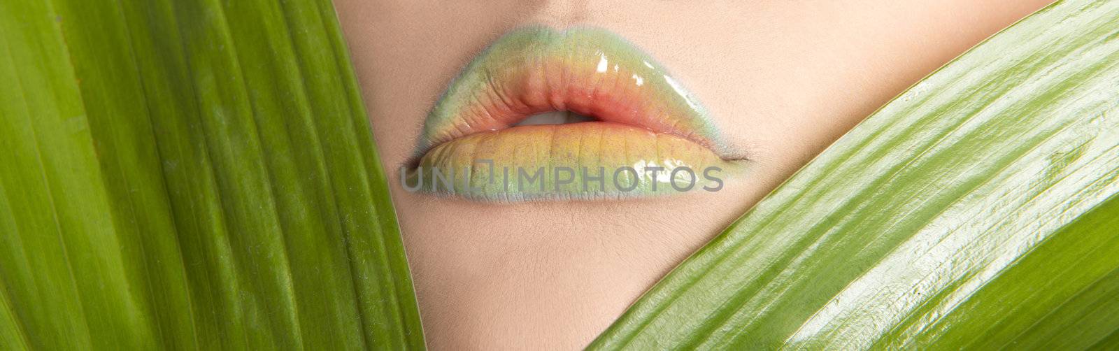 Woman's lips with green leafs