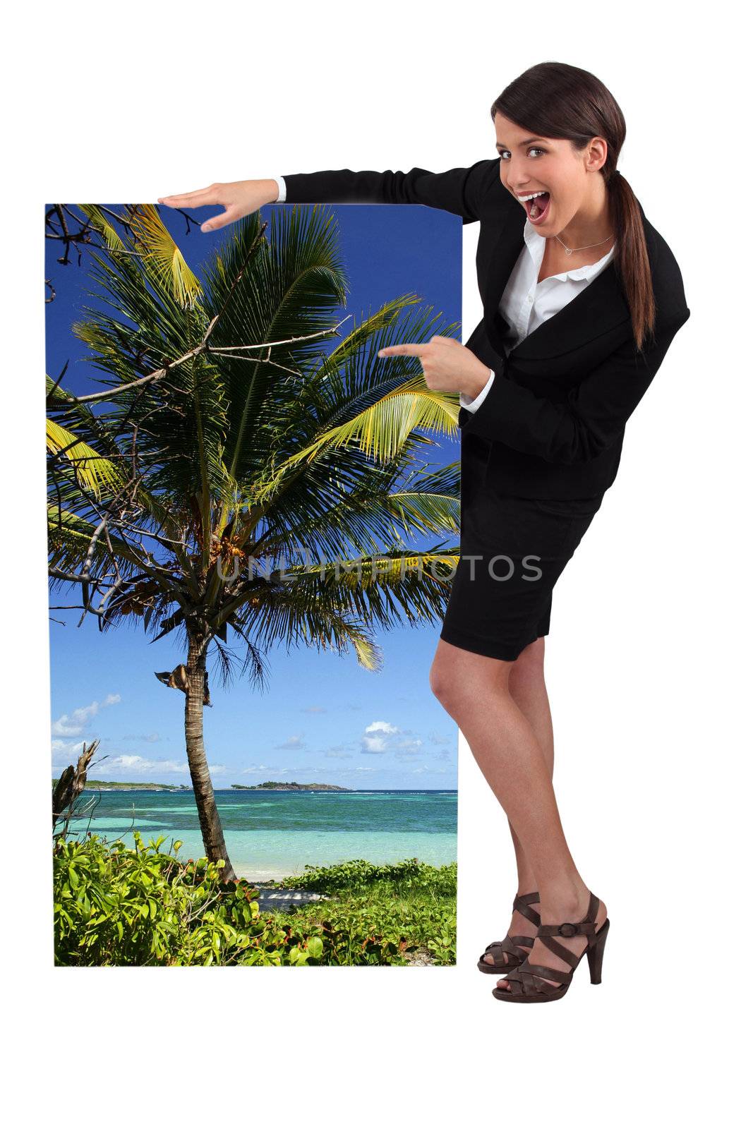 female travel agent showing poster of tropical beach