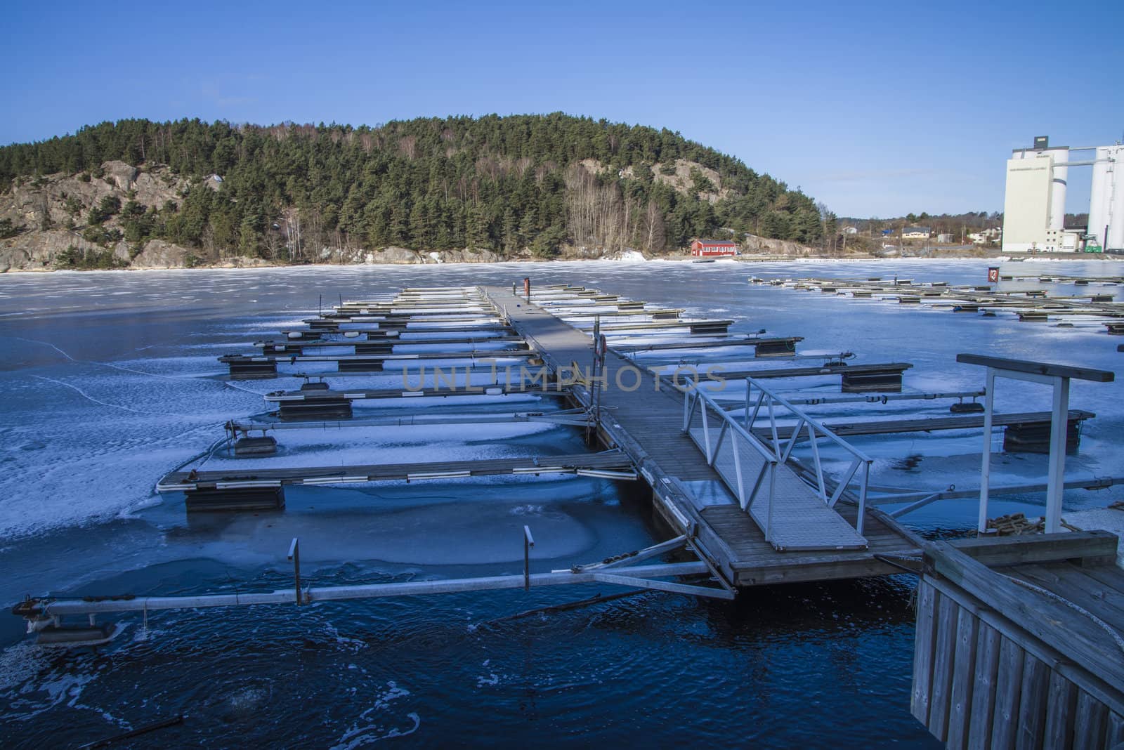 Floating docks are frozen in the ice at the harbor of Halden, Norway. The picture was shot one day in March 2013.