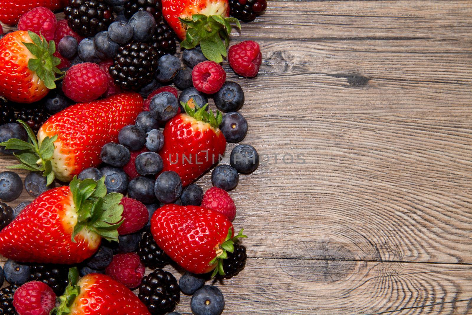 Berries on Wooden Background by lsantilli
