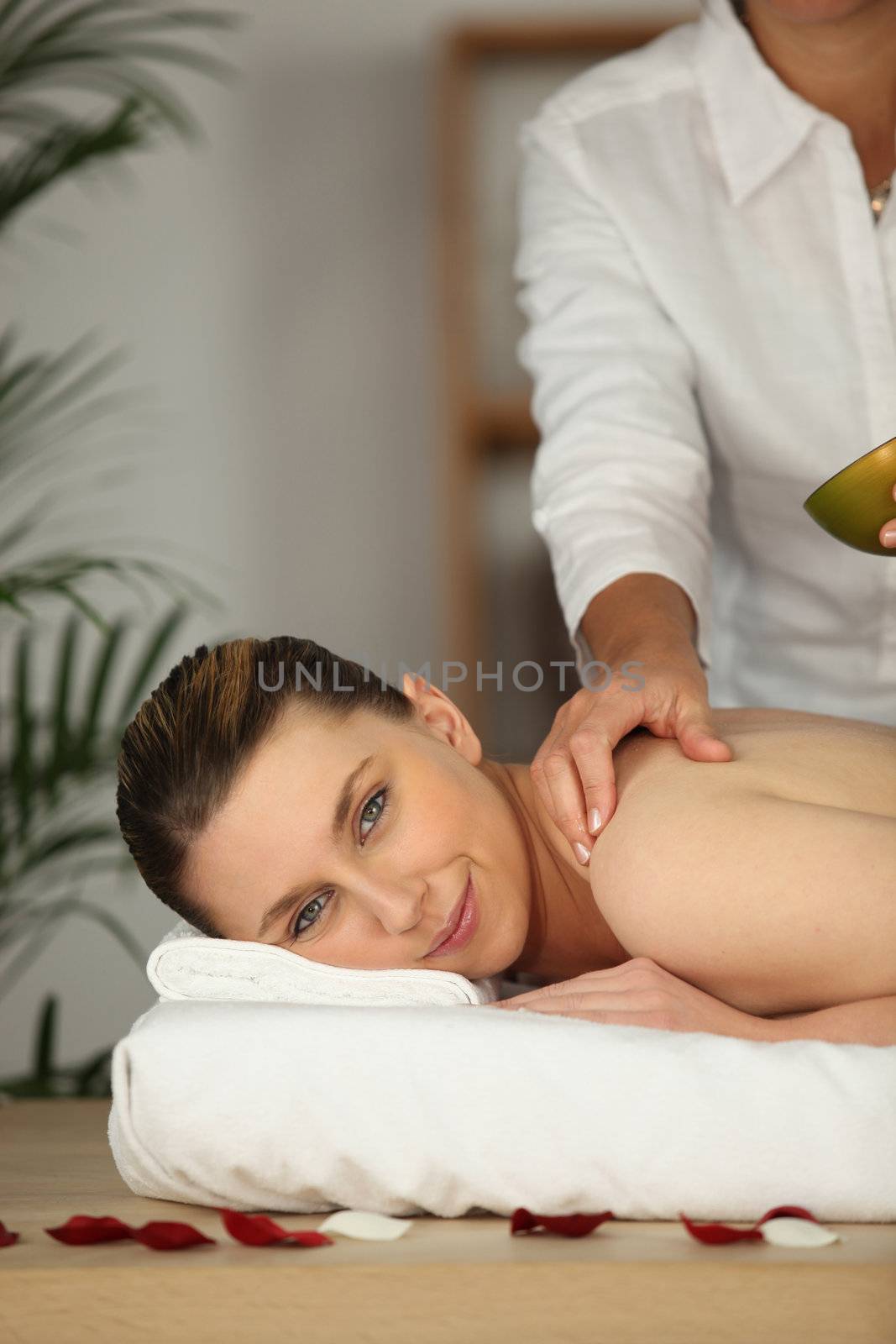 Happy woman being massage in beauty parlor by phovoir