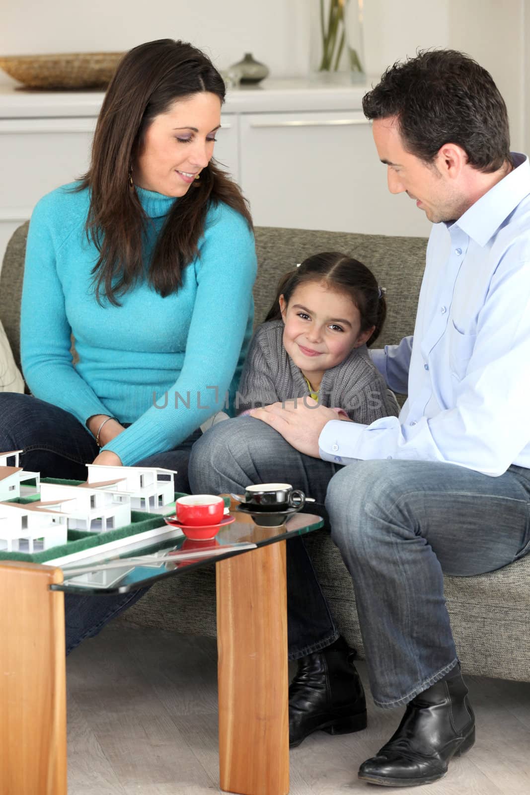 Family looking at a new-build model by phovoir