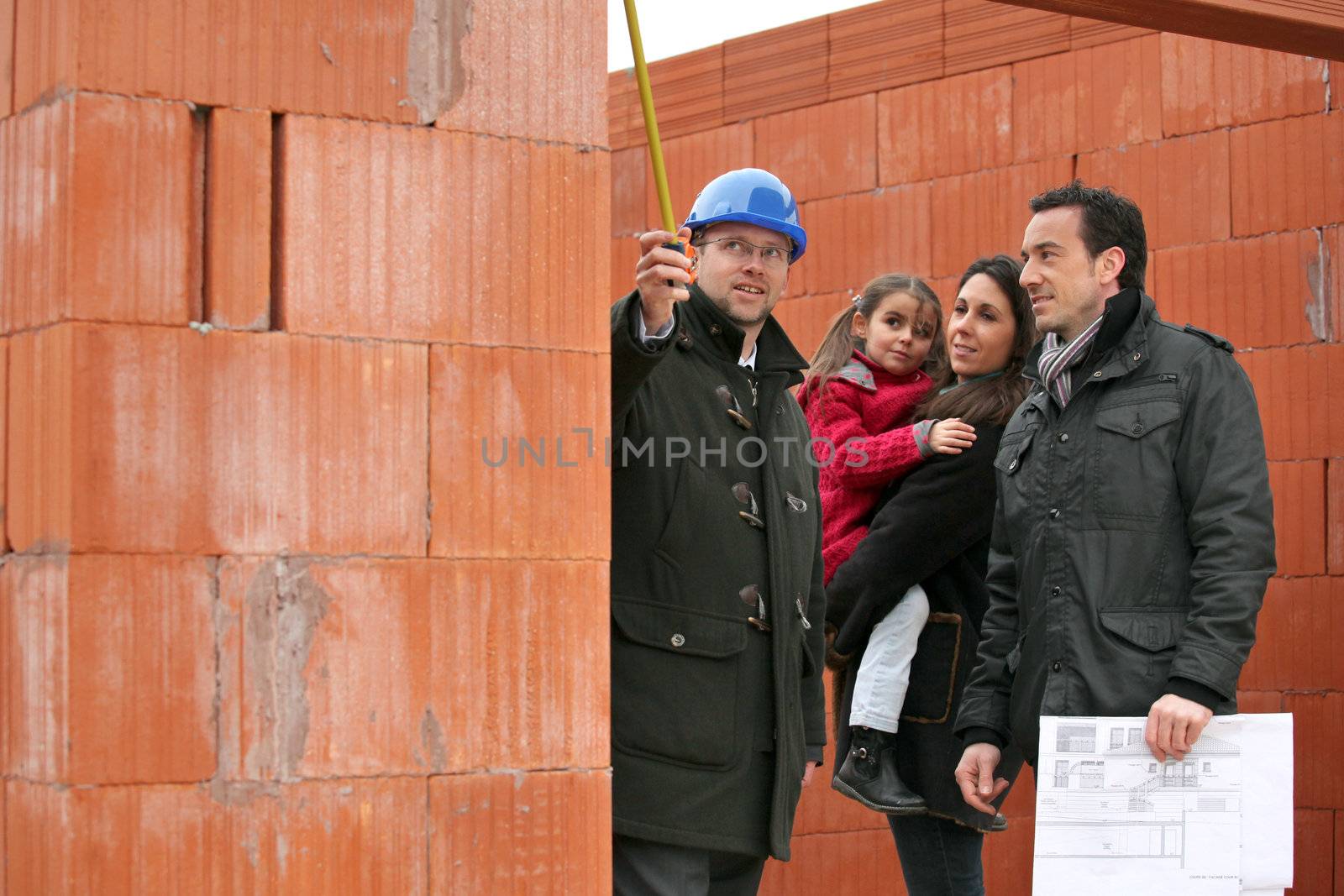 real estate businessman and a family on a construction site