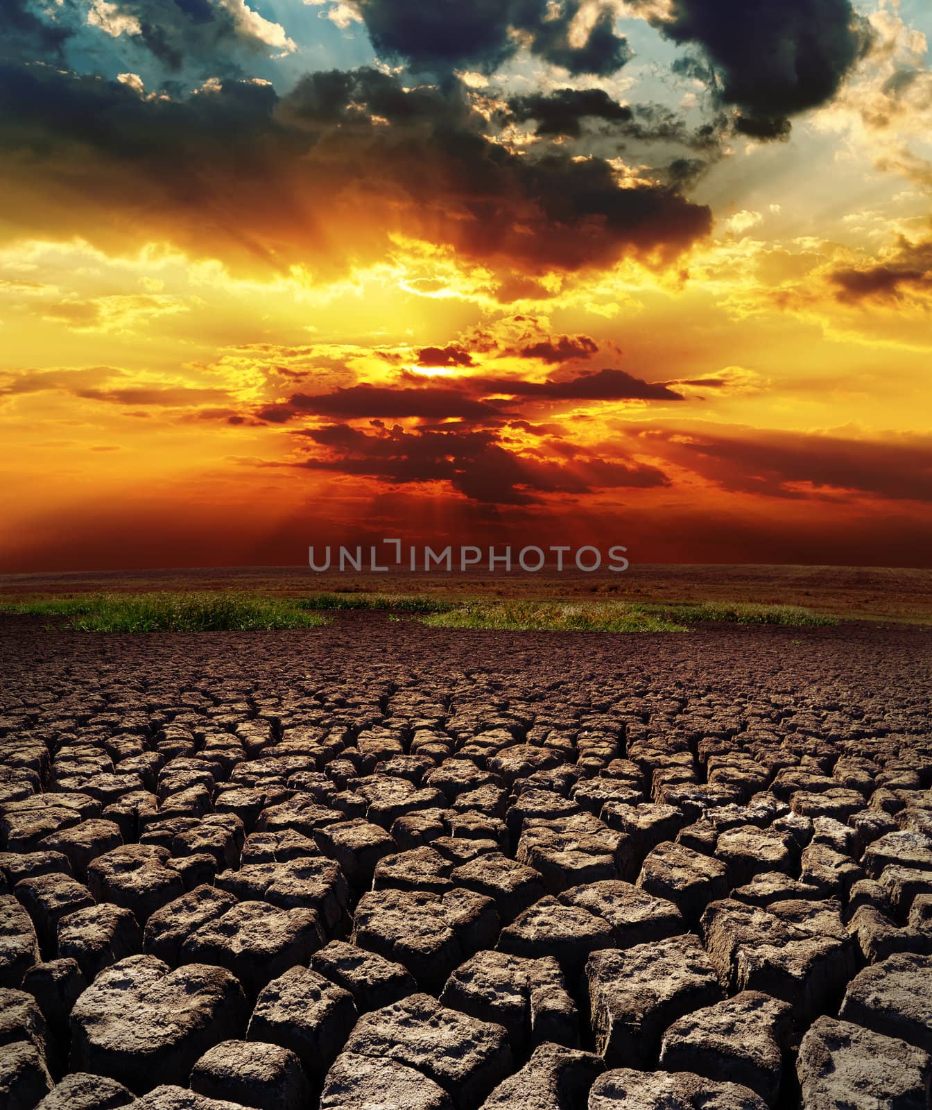 dramatic sunset over drought land by mycola