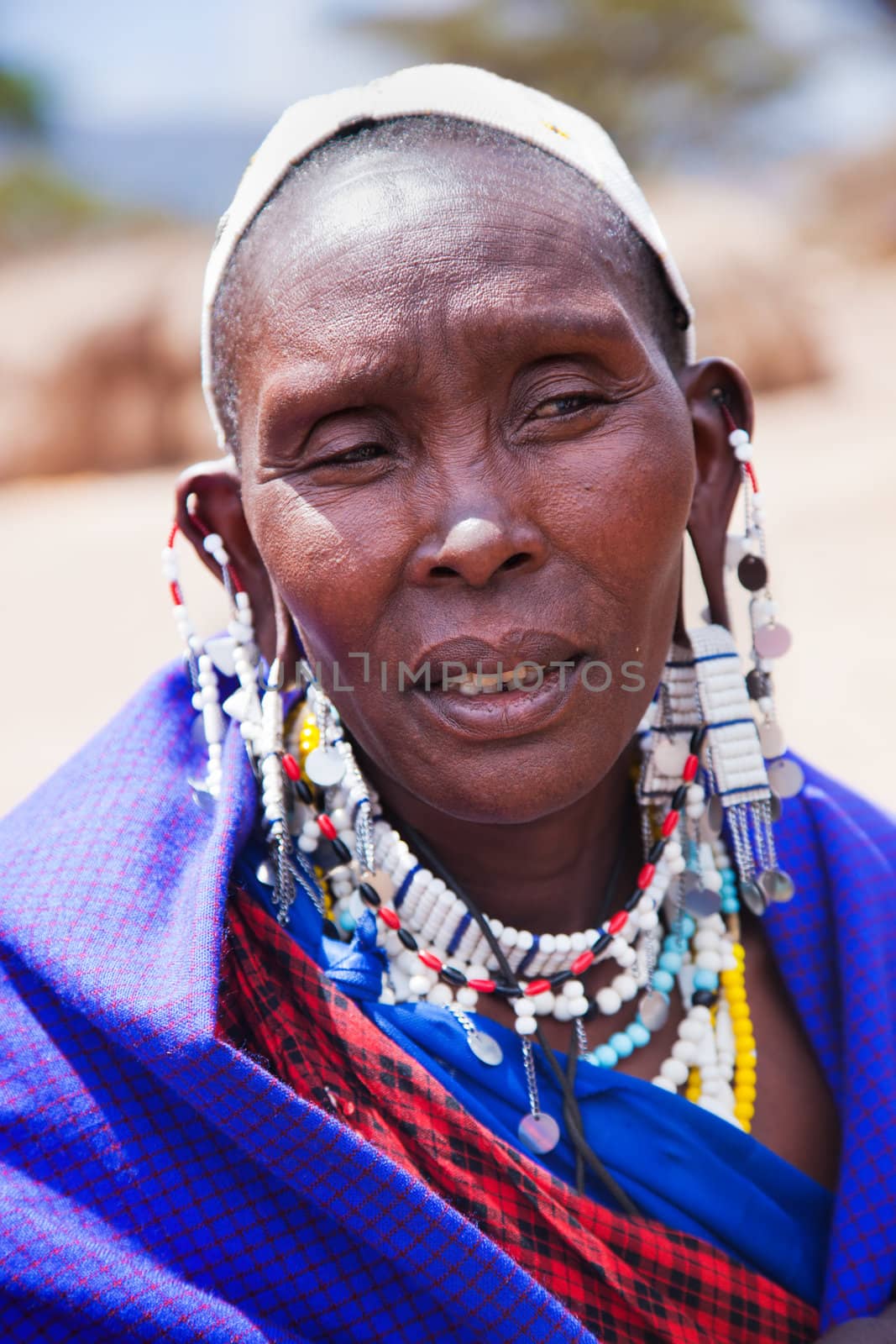 Maasai village, TANZANIA, AFRICA - DECEMBER 11: Maasai woman portrait in traditional clothes on December 11, 2012 in Ngorongoro Tanzania. Maasai people are among the best known of African ethnic groups located in Kenya and northern Tanzania.