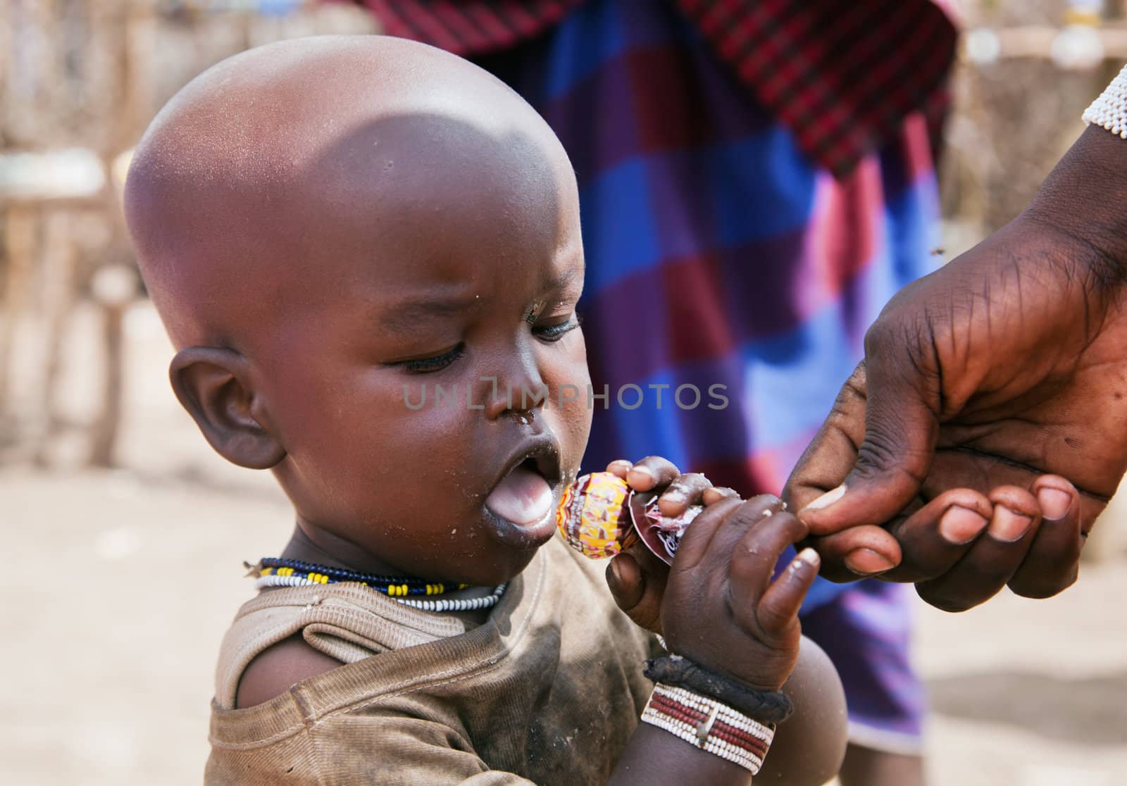 Maasai village, TANZANIA, AFRICA - DECEMBER 11: A three year old Maasai child named Sabore trying a Chupa Chups lollipop which has been given by tourists on December 11, 2012 in Ngorongoro Tanzania. 