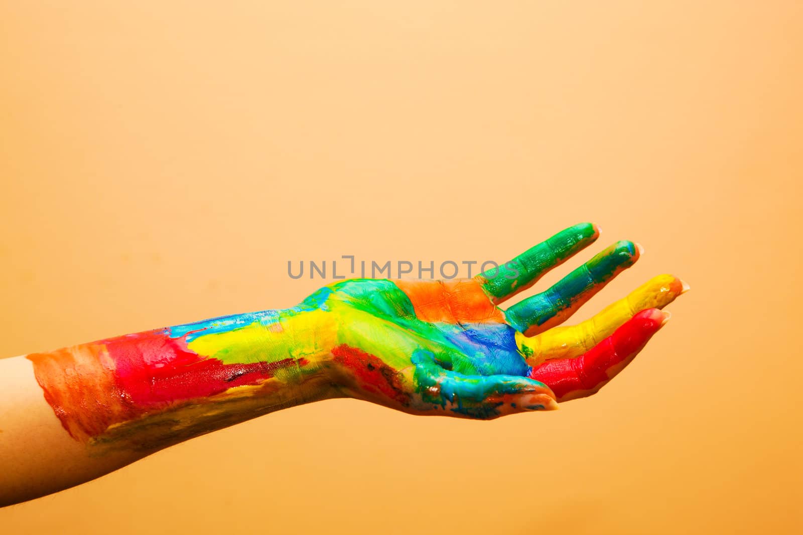 Painted hand, colorful fun. Creative, funny and artistic means happy! Orange background wall