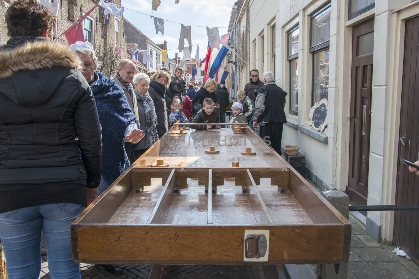 Brielle, Holland - April 1, 2013: children playing dutch shuffleboard on the annual market celebrating the uprising of Low Countries against Spain in the 80 Years' War