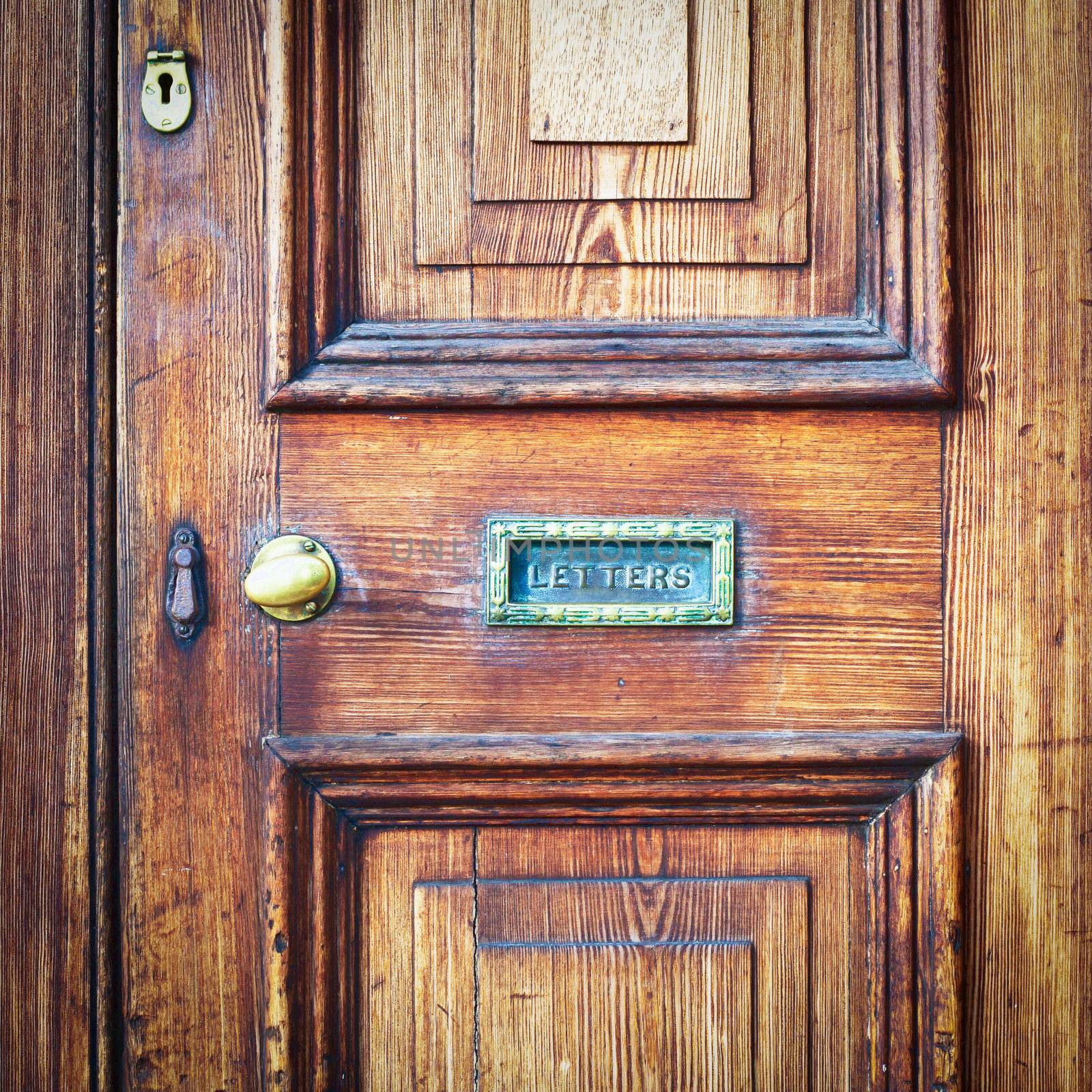A wooden vintage front door with a letter box