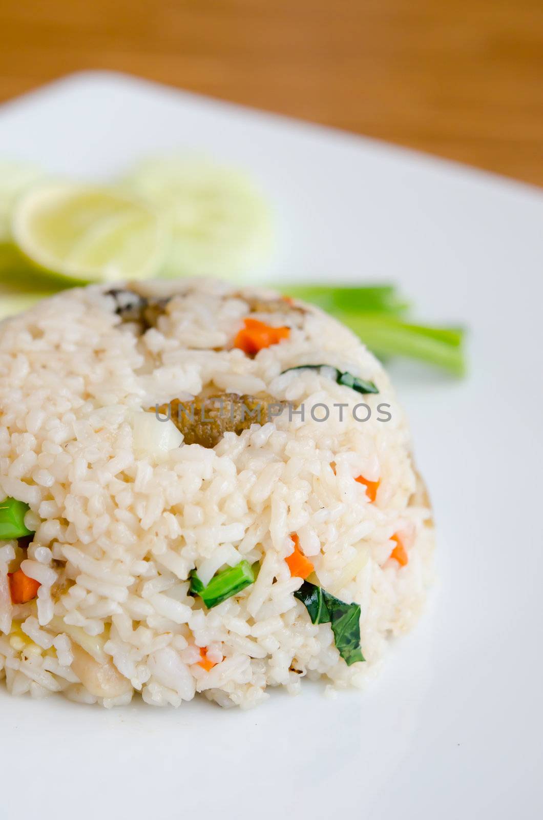 Mixed cooked rice with fried fish , sauce and  vegetable on dish