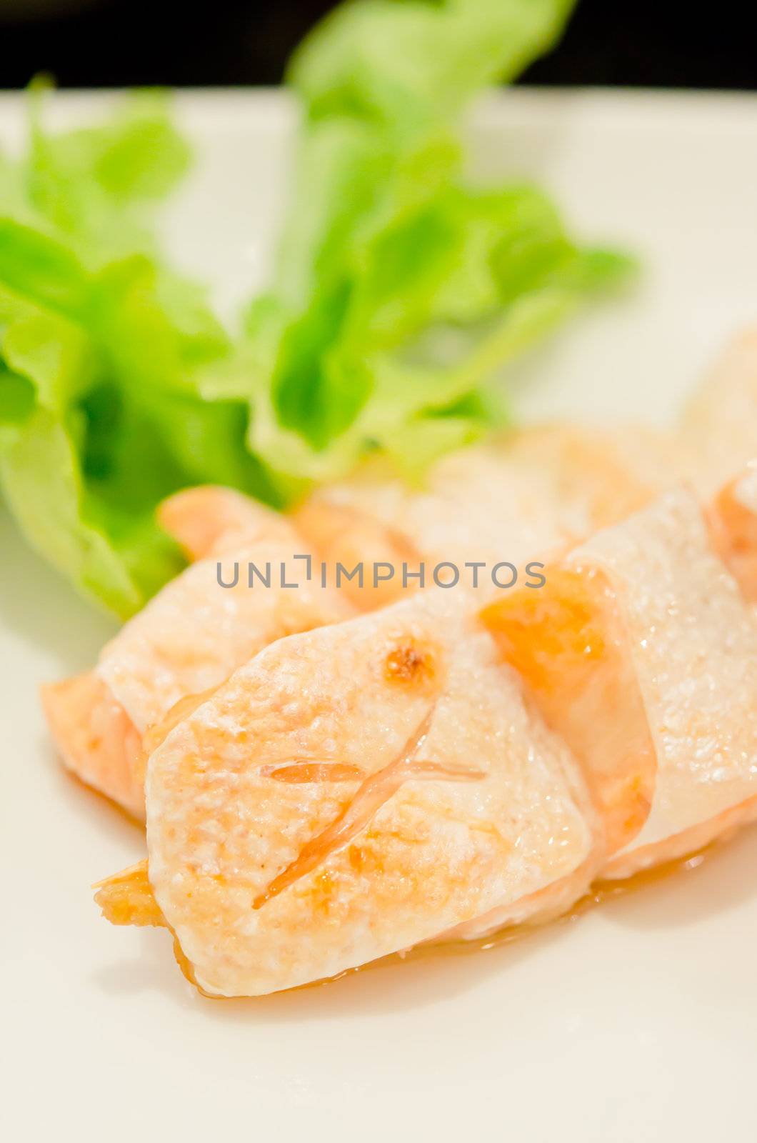 Grilled salmon belly served with fresh lettuce .