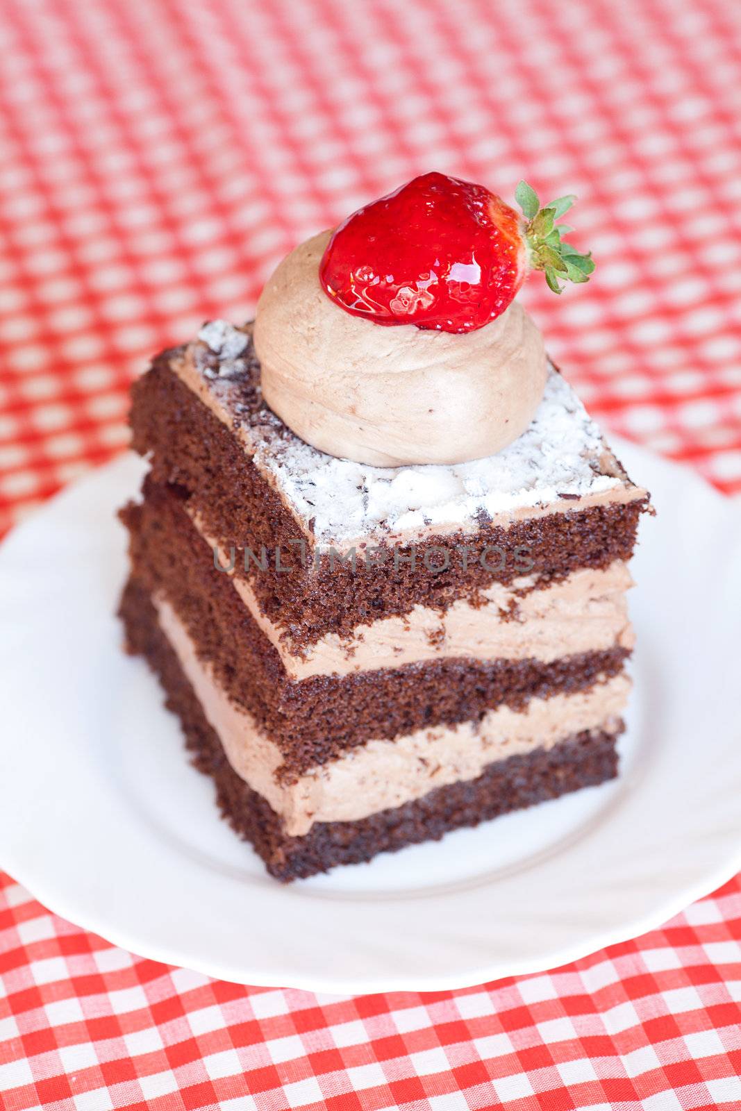 beautiful cake with strawberry on plaid fabric