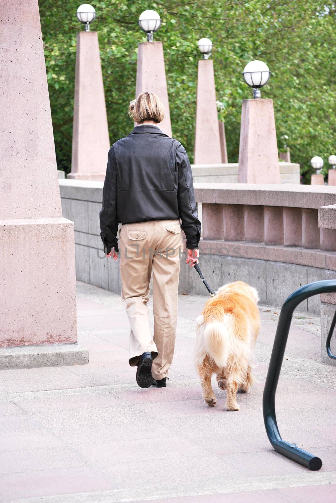 Female walking her dog outside.