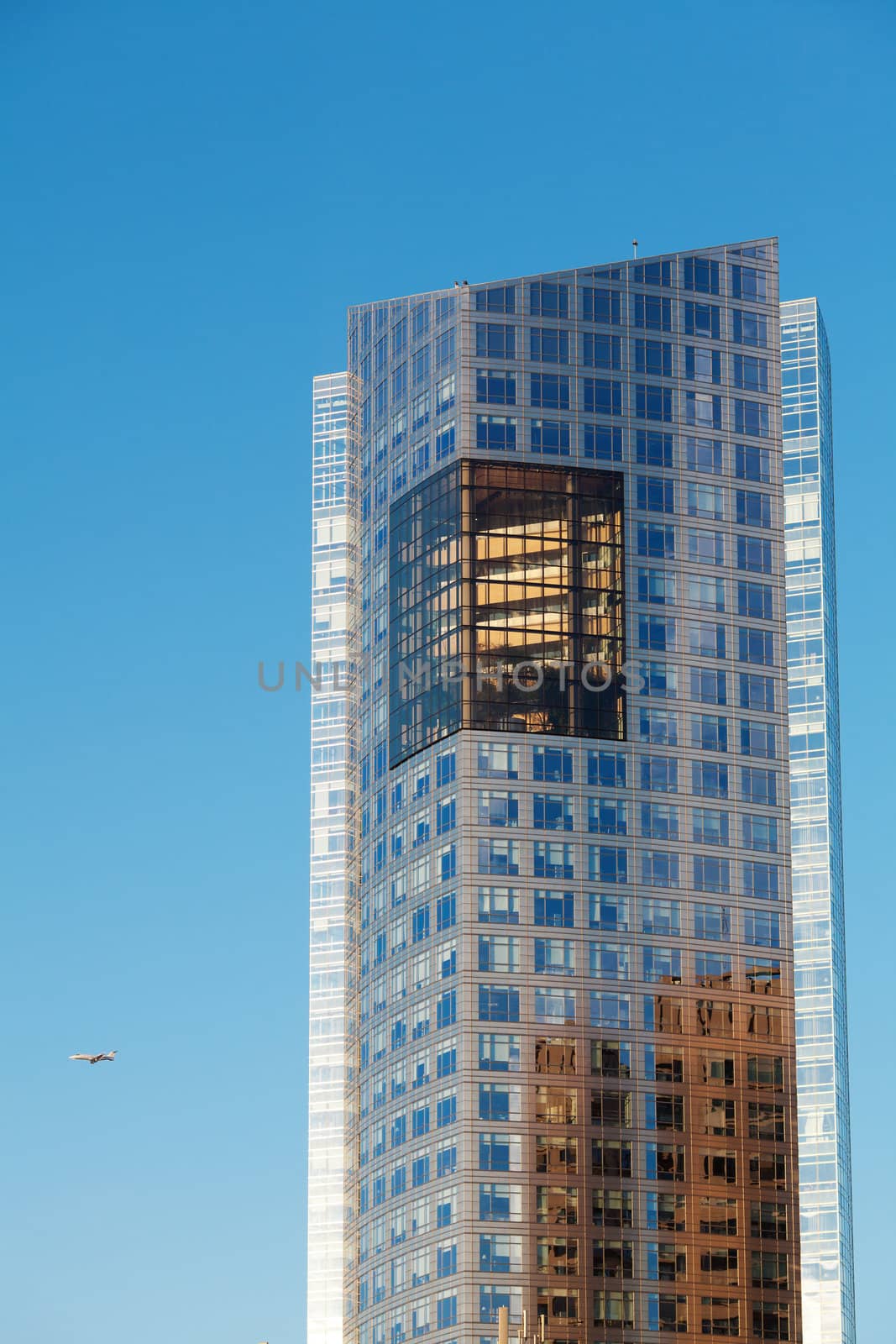 Beautiful modern office building and airplane against the blue s by jannyjus