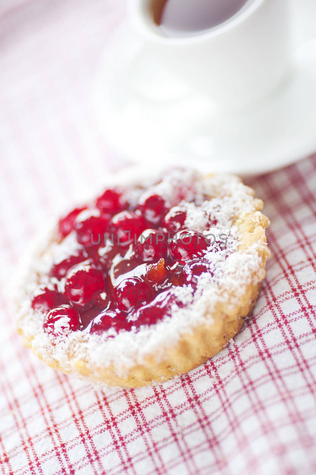 beautiful cake with berries and tea on plaid fabric