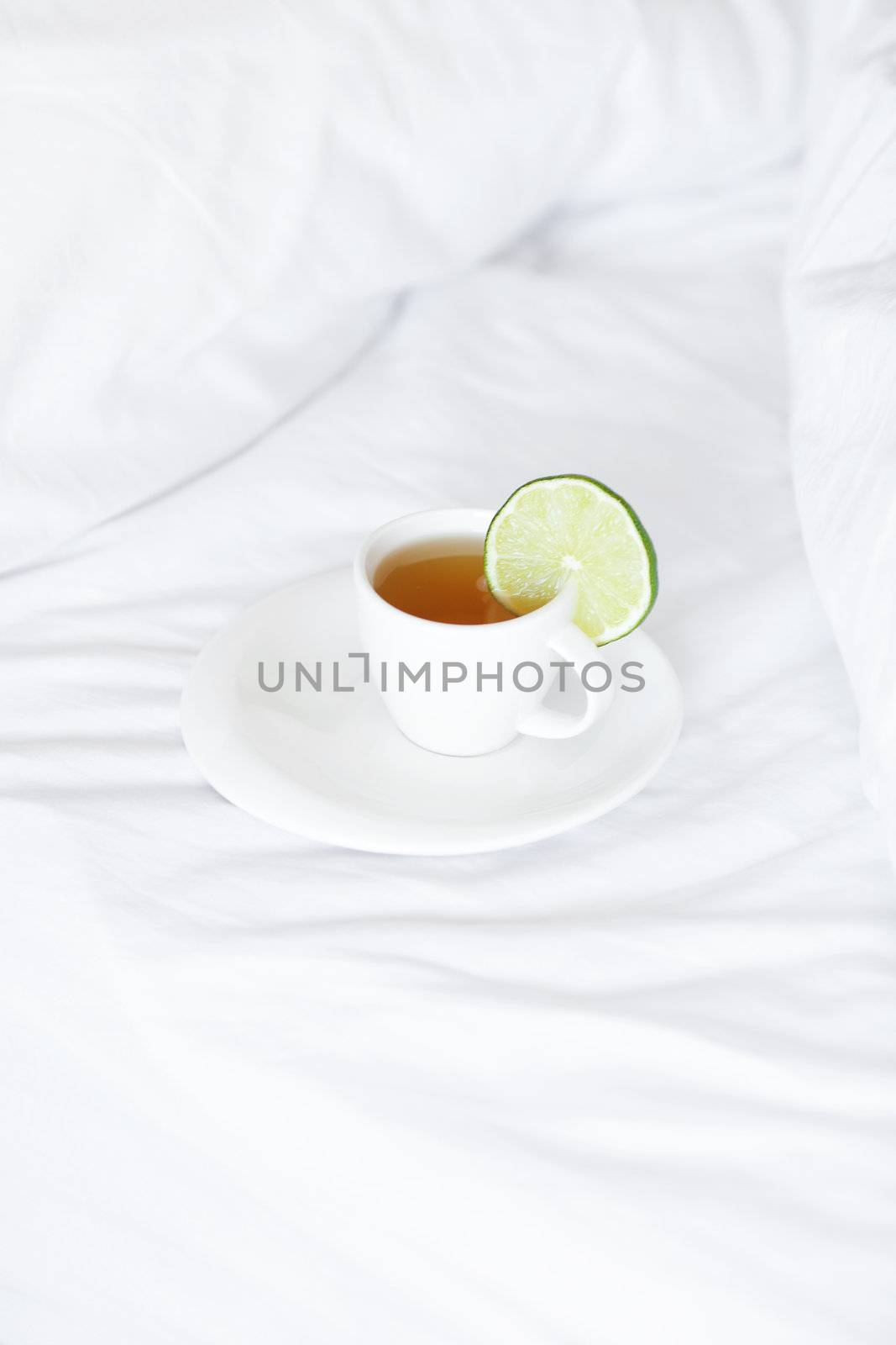 bed with a pillow and a cup of tea 