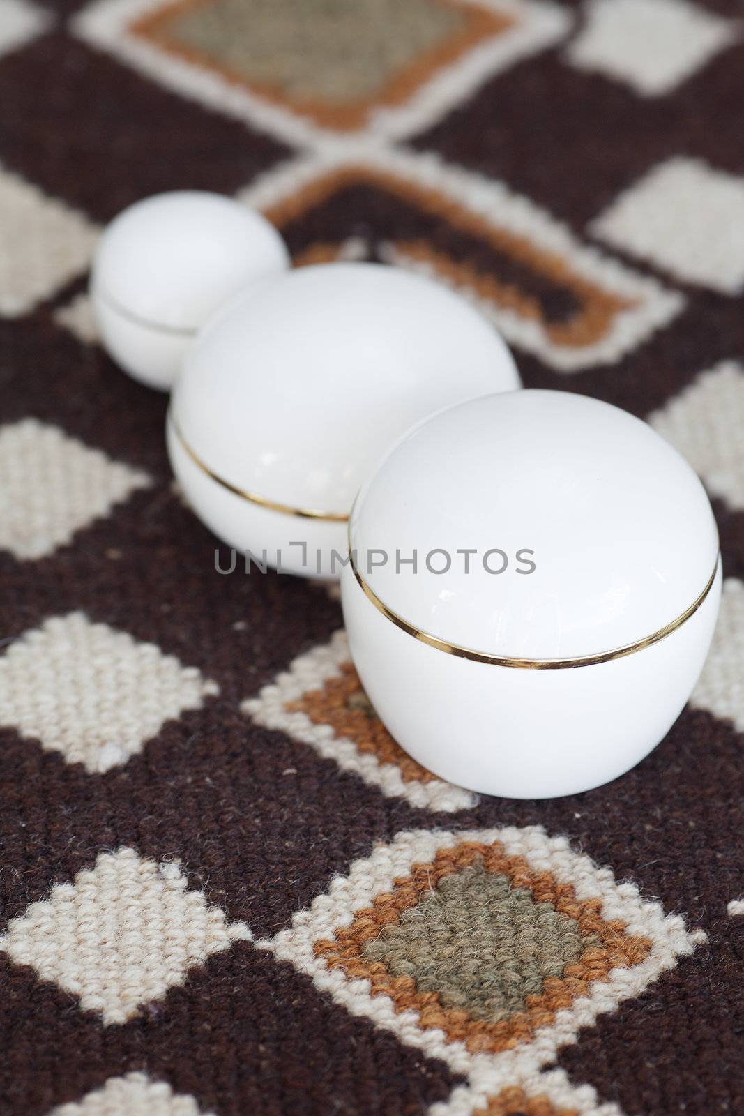 cosmetic containers lying on ethnic mat by jannyjus