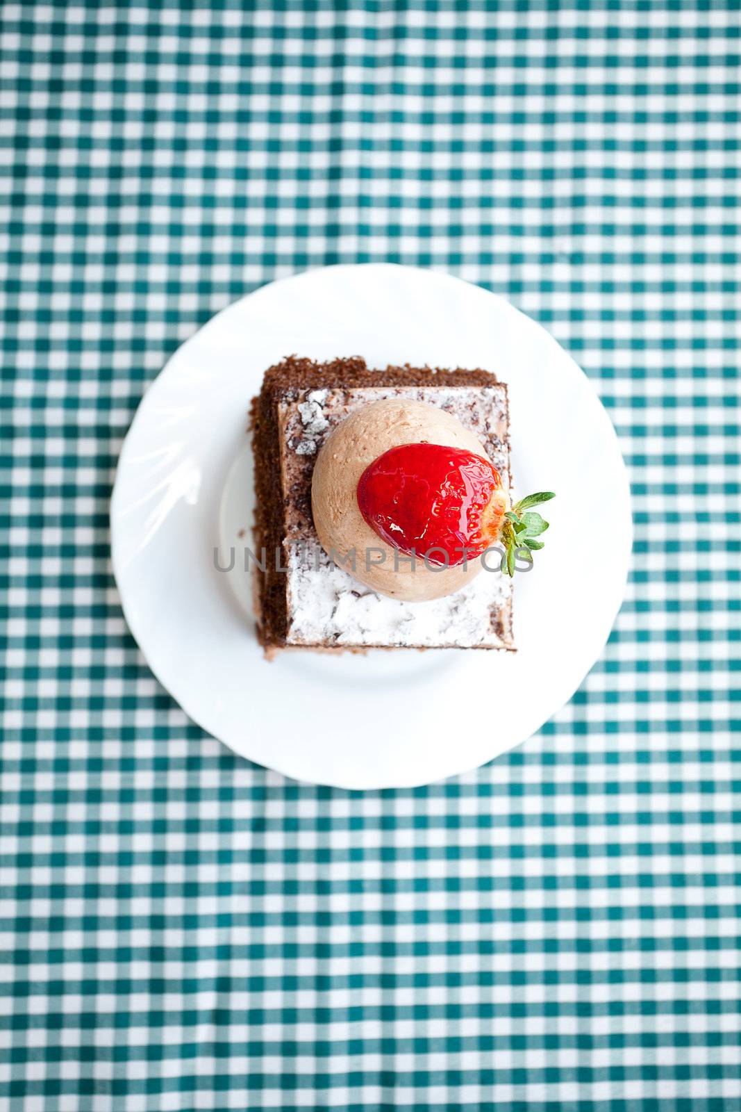 beautiful cake with strawberry on plaid fabric