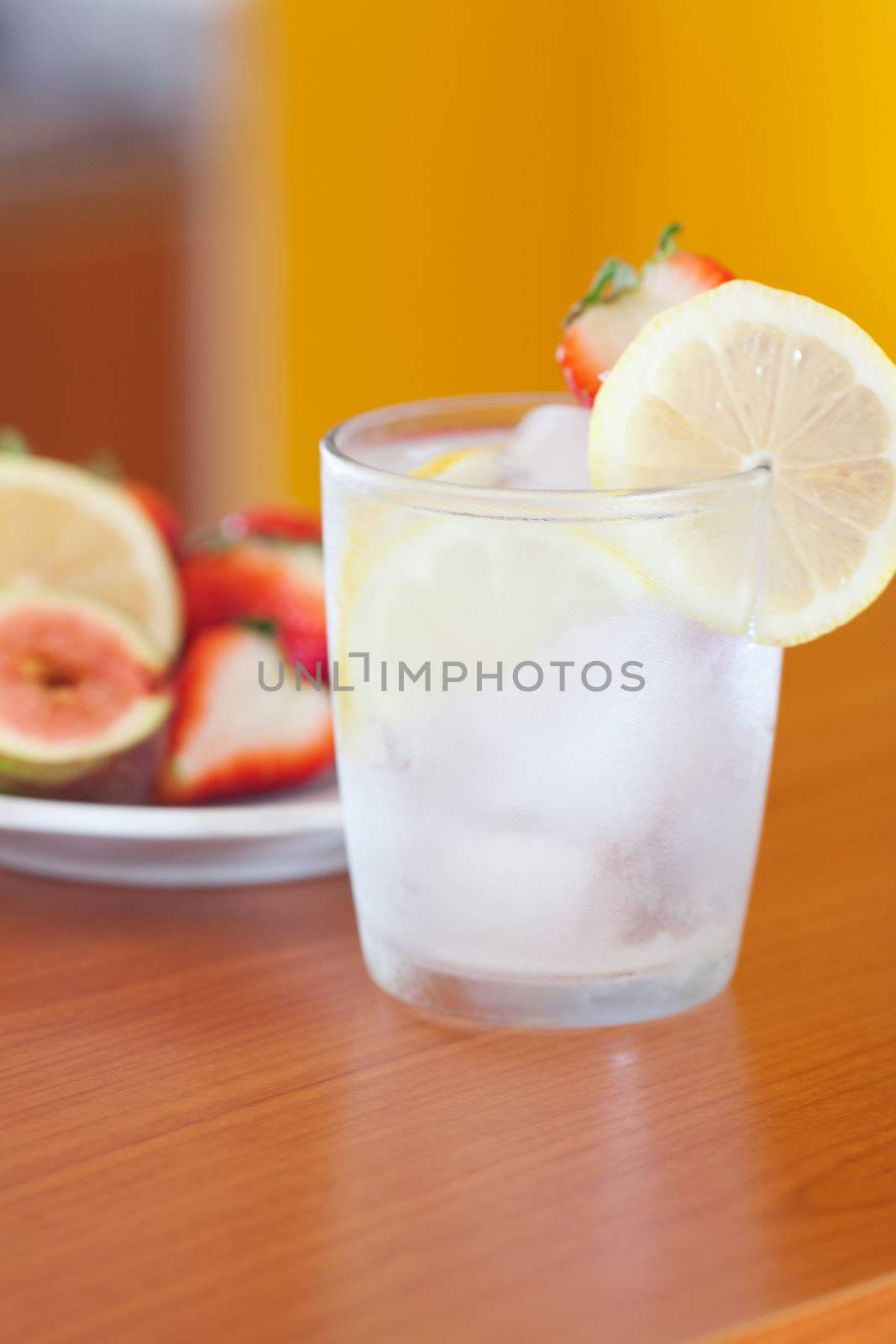 cocktail with ice,lemon, fig and strawberries on a plate