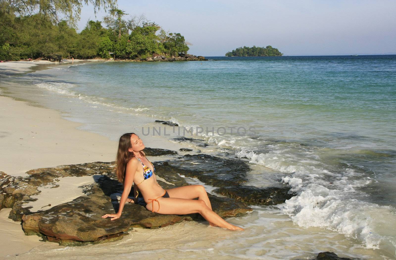Young woman sitting on a beach of Koh Rong island, Cambodia, Southeast Asia