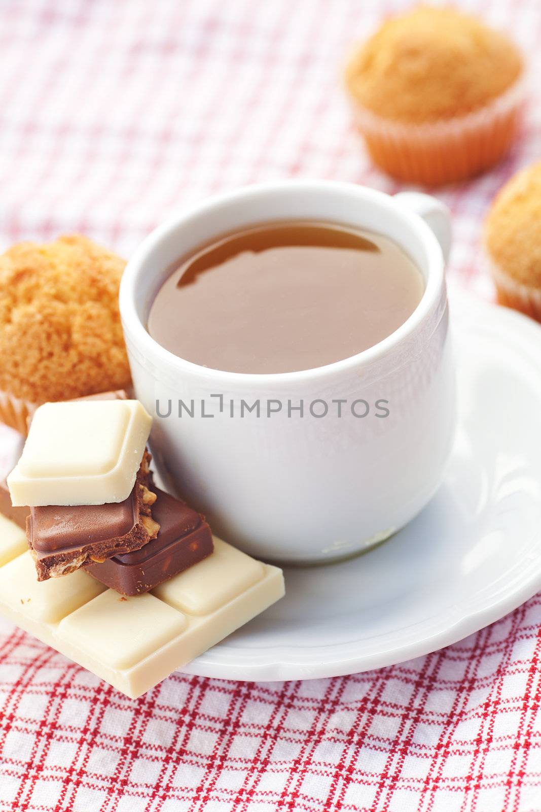 bar of chocolate,tea and muffin on plaid fabric