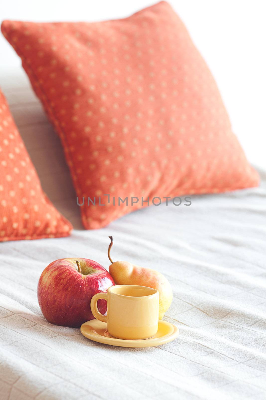 cup of tea,apple and pear on the bed