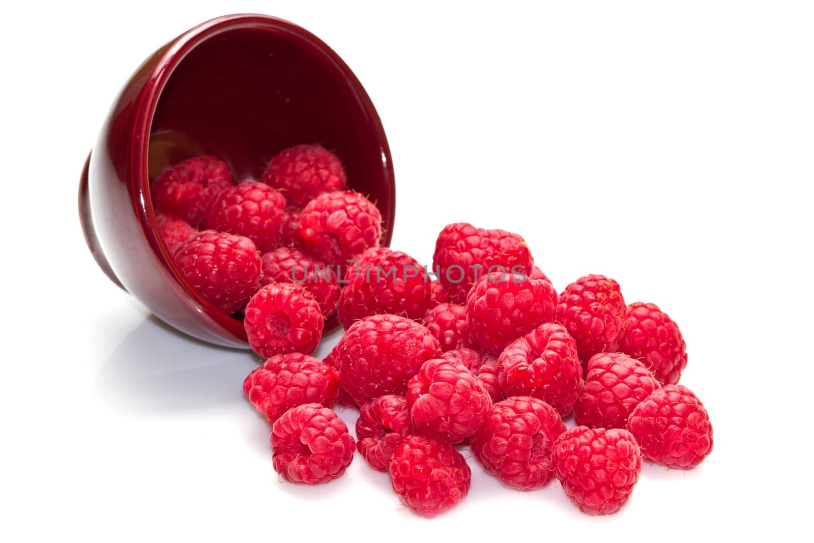 fresh raspberries scattered on white background 