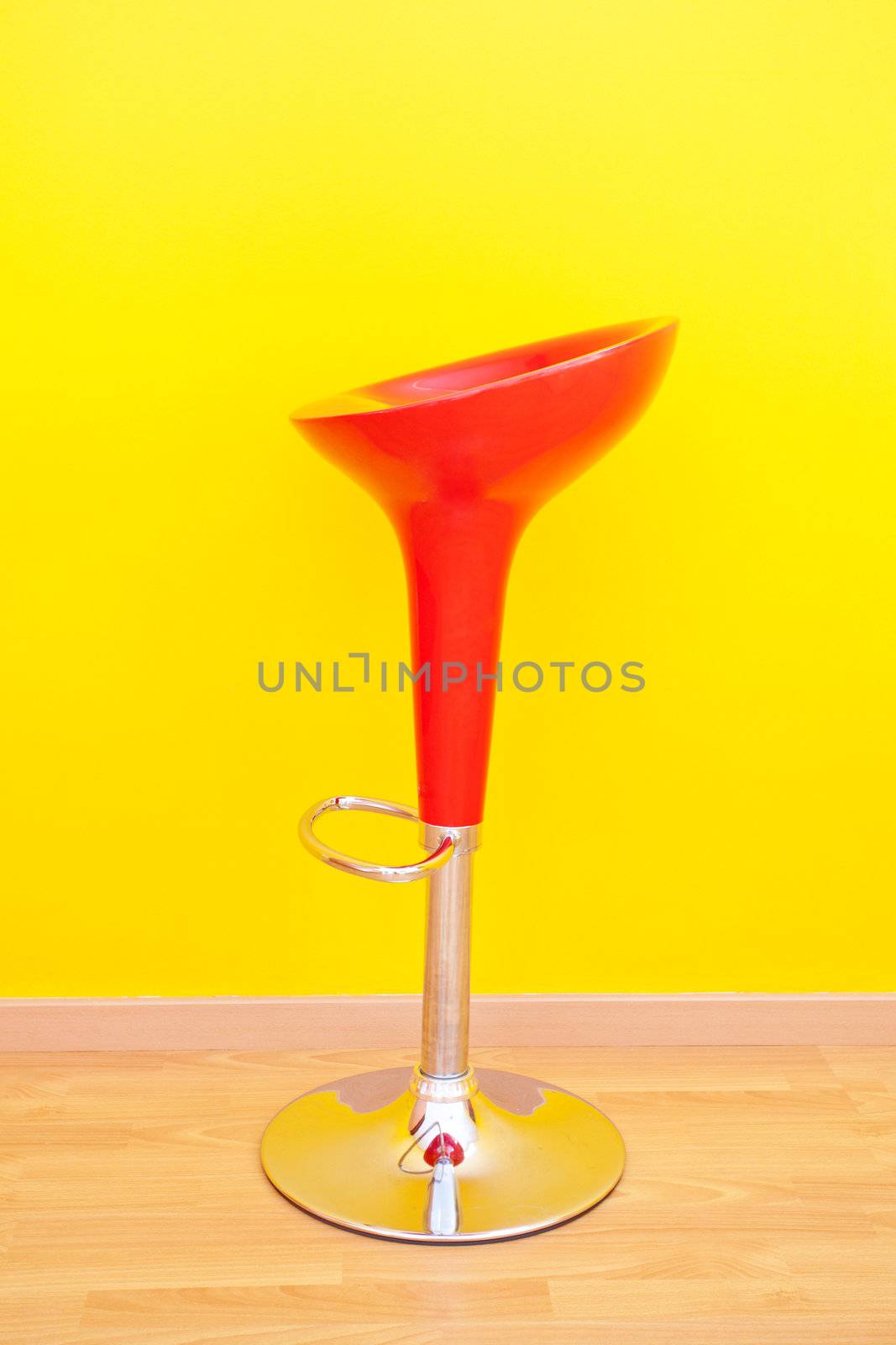 bar chair against a yellow wall in the apartment