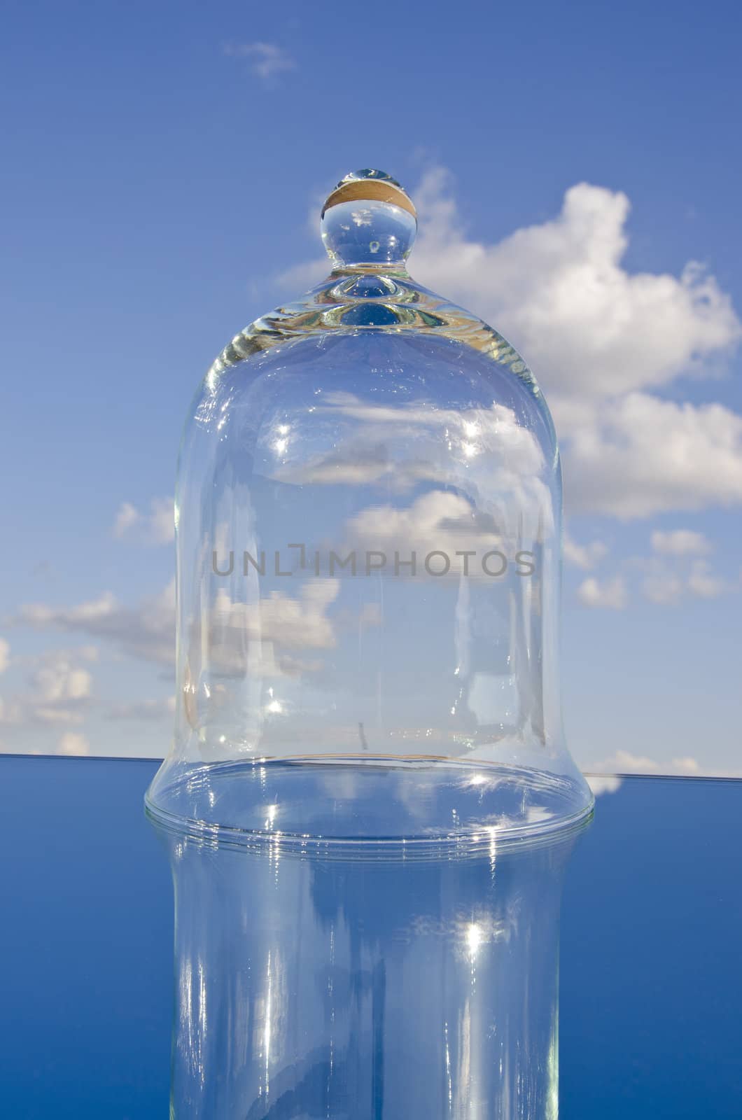 empty glass bell on mirror and blue sky space