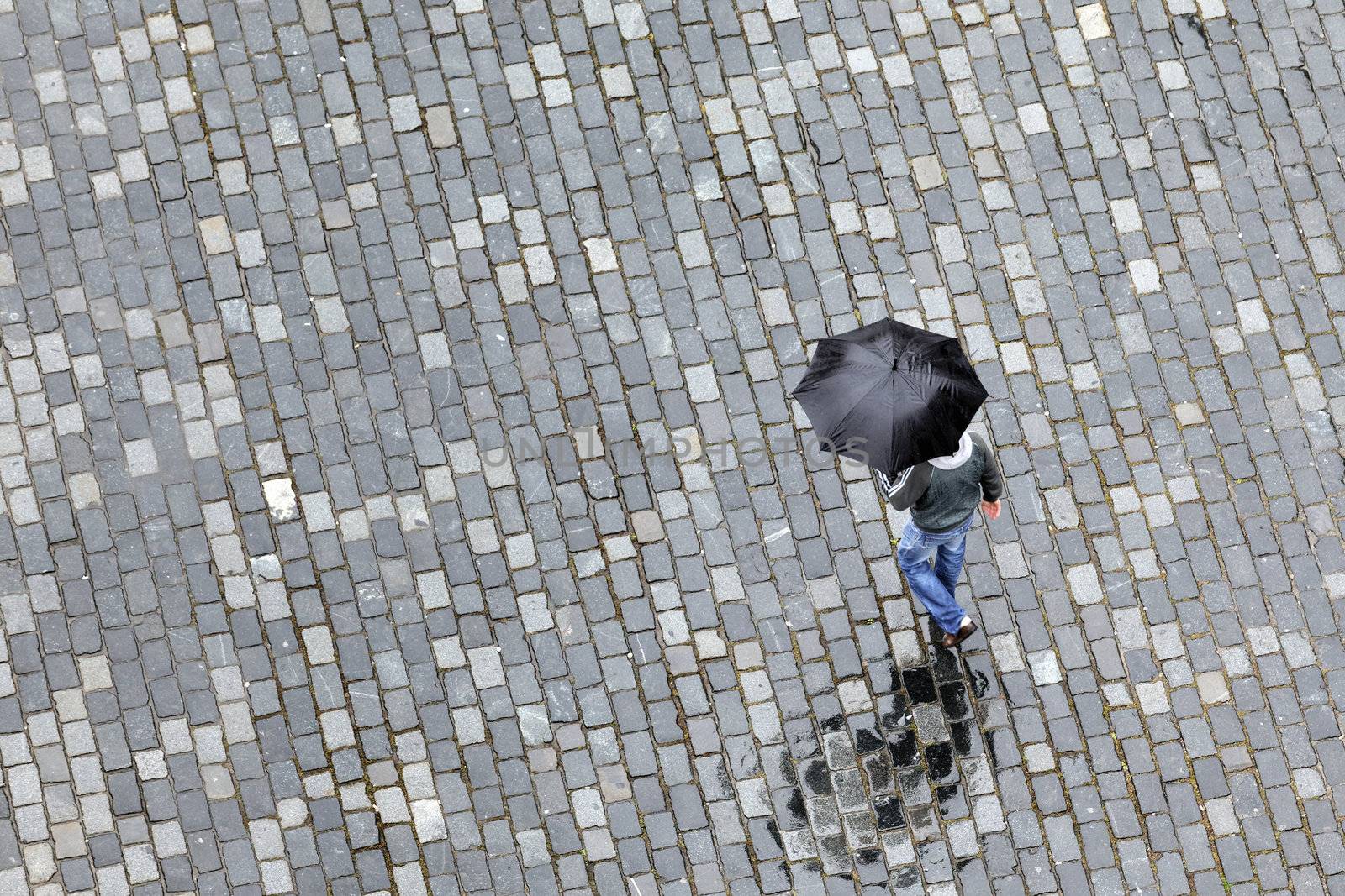 man with umbrella walking under the rain