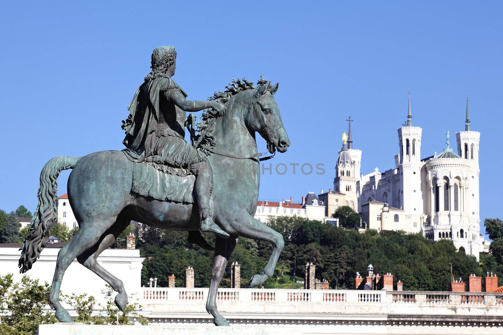 famous statue of Louis XIV and Basilique Fourviere on a background 