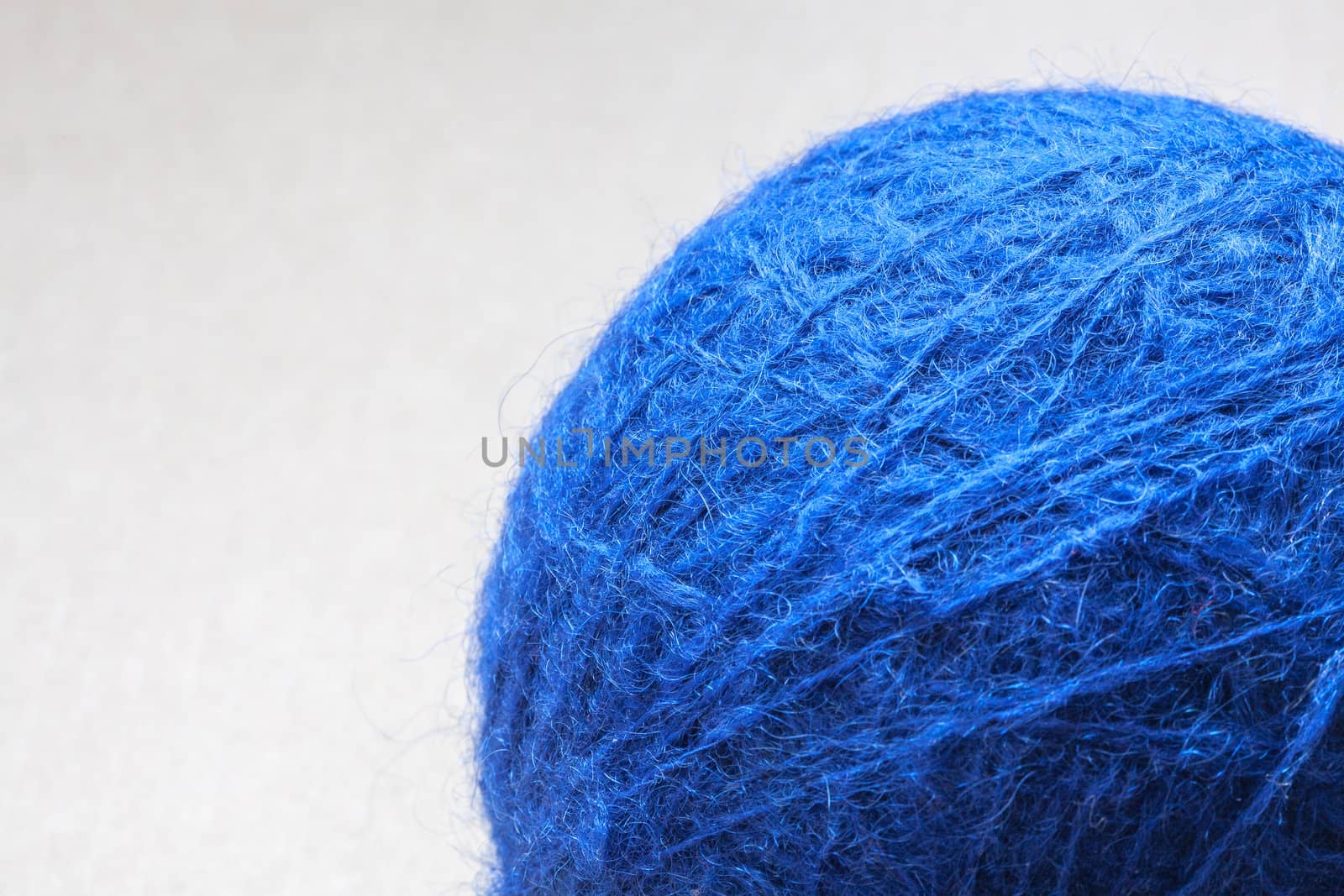 blue wool yarn skein on cardboard background by sfinks