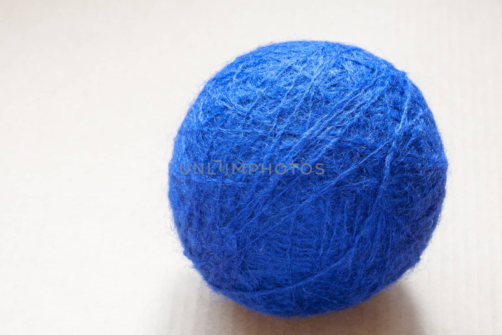 blue wool yarn skein on cardboard background