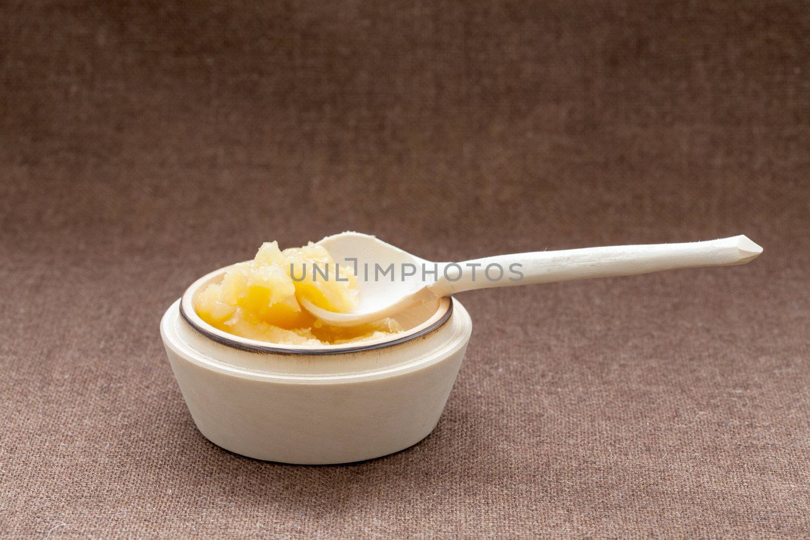 Pot of honey and wooden dipper on a sackcloth by sfinks