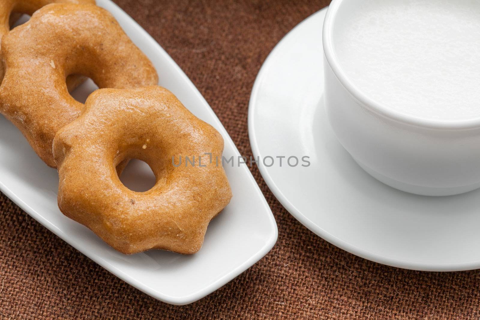 honey cookies on a plate and a cup of milk by sfinks