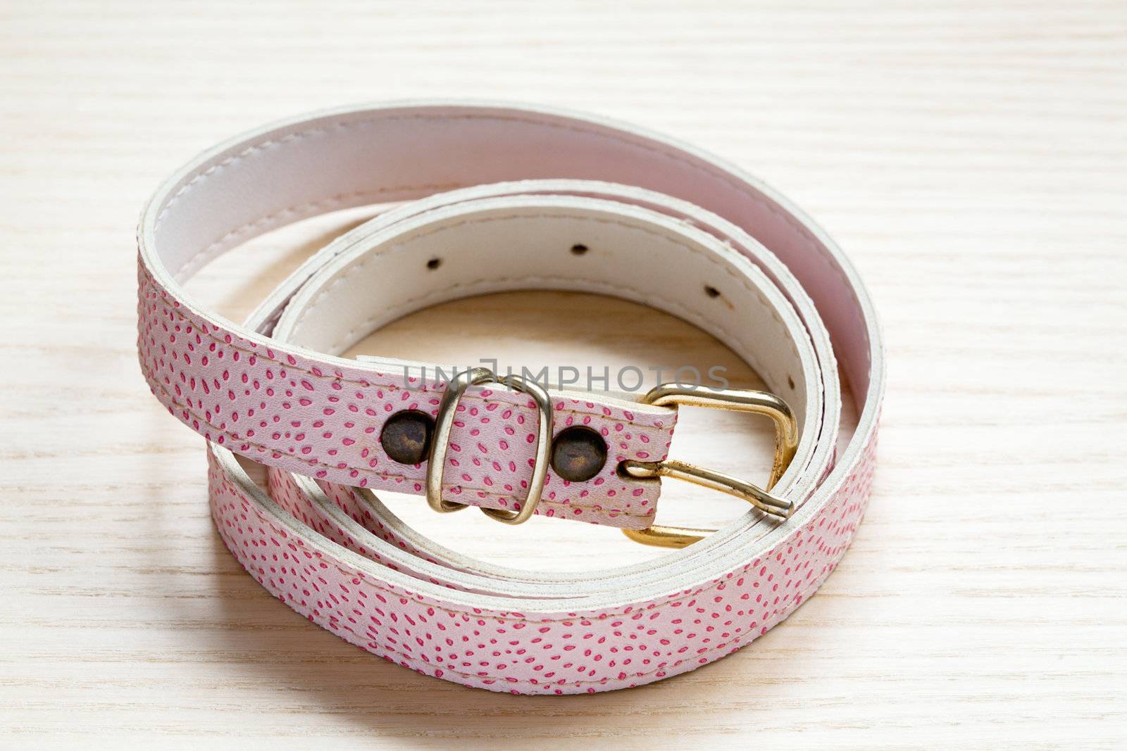 pink women style belt on a light wooden background by sfinks