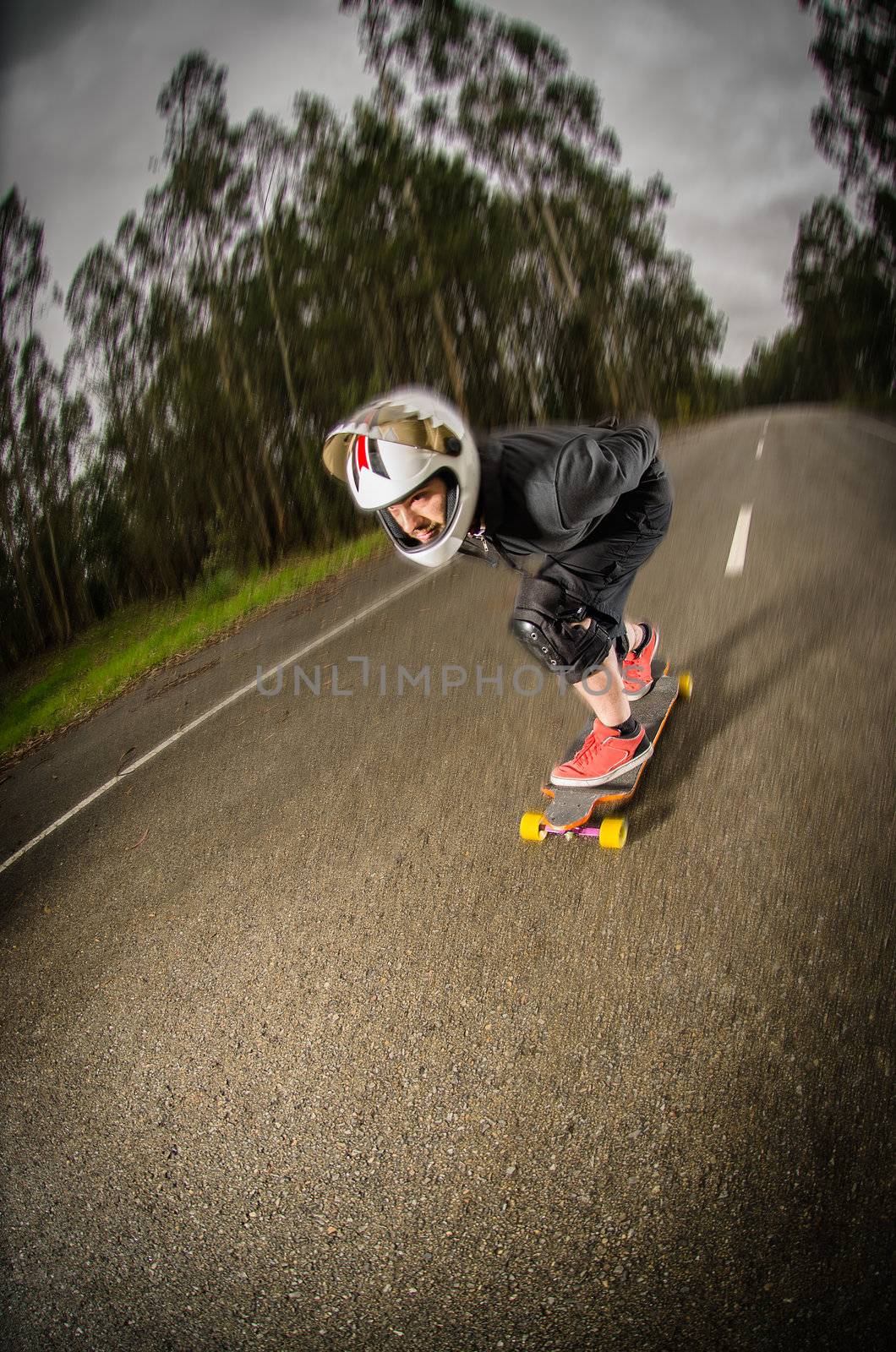 Downhill skateboarder in action on a asphalt road.