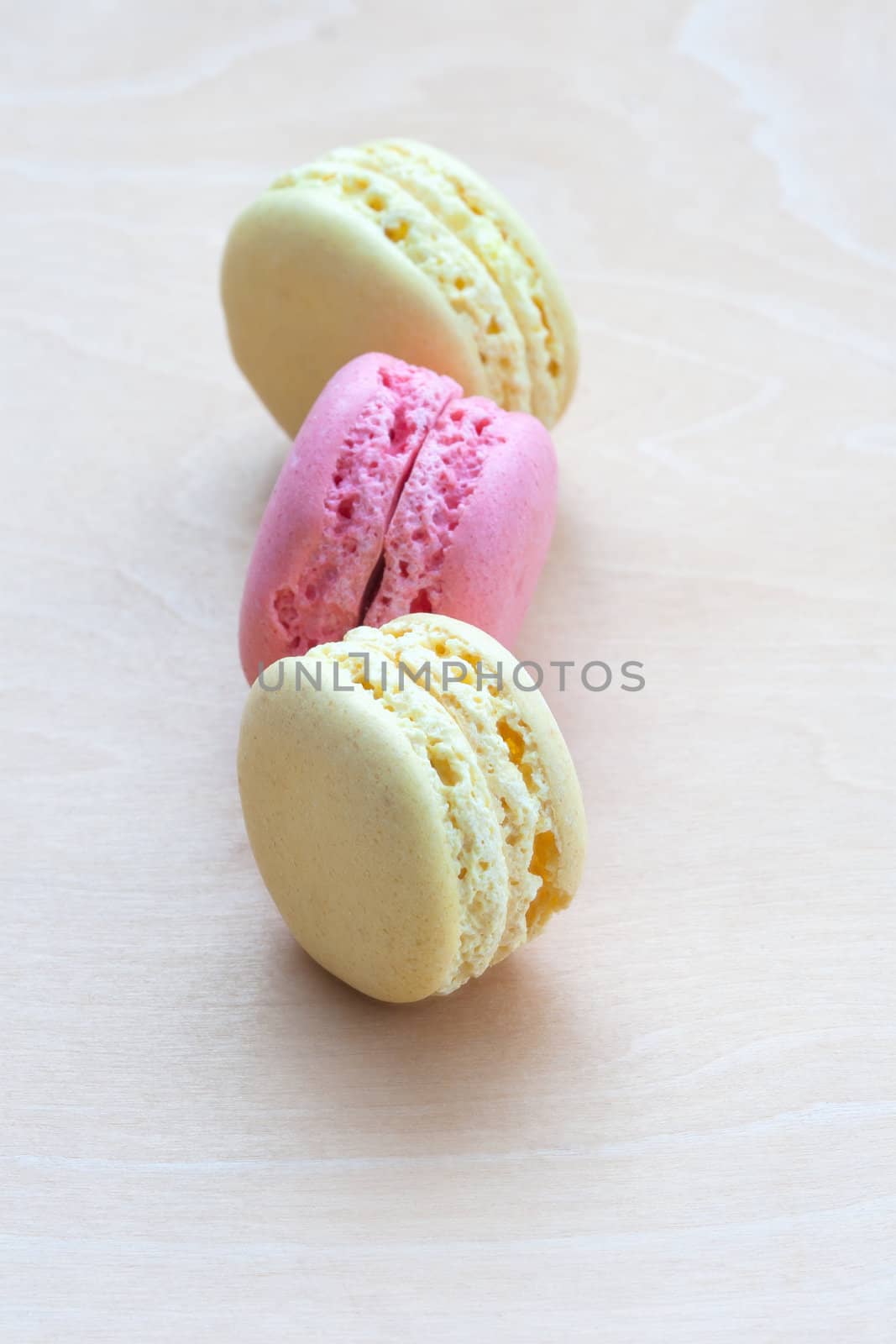 Colorful macaroons on wooden background by sfinks