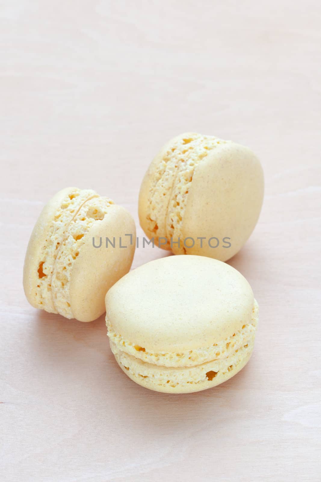 yellow macaron on wooden background by sfinks