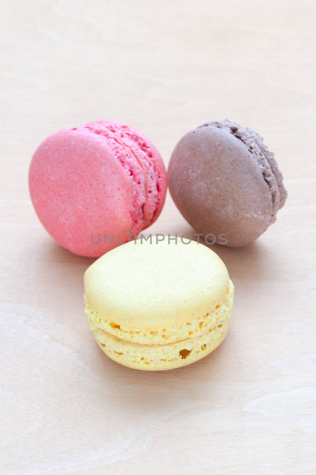 colored macaron on wooden background by sfinks