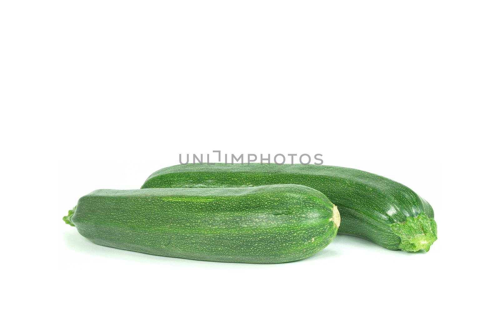 two fresh and green courgettes on white background