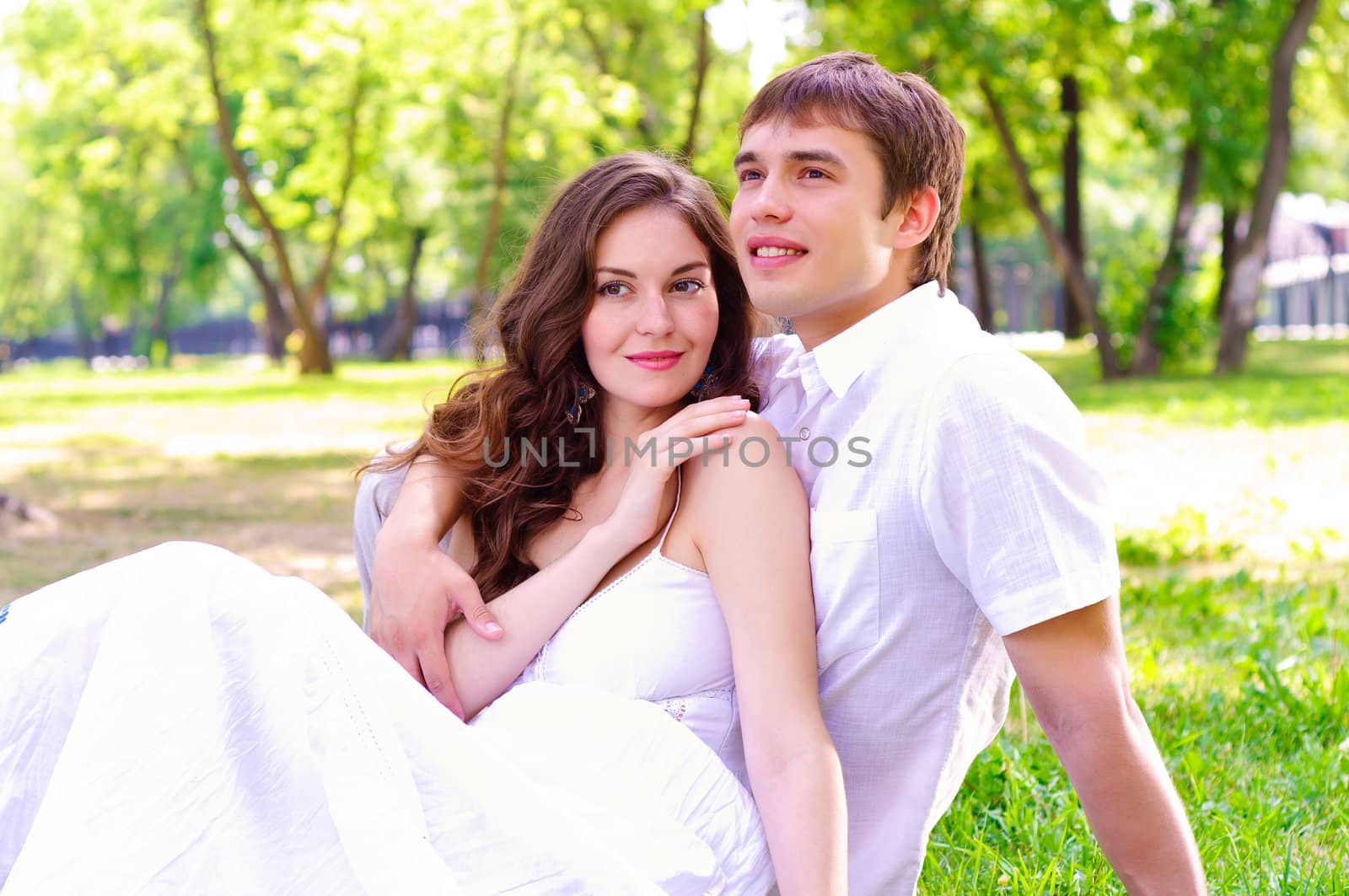 couple in the park sitting on the grass, have a good time together