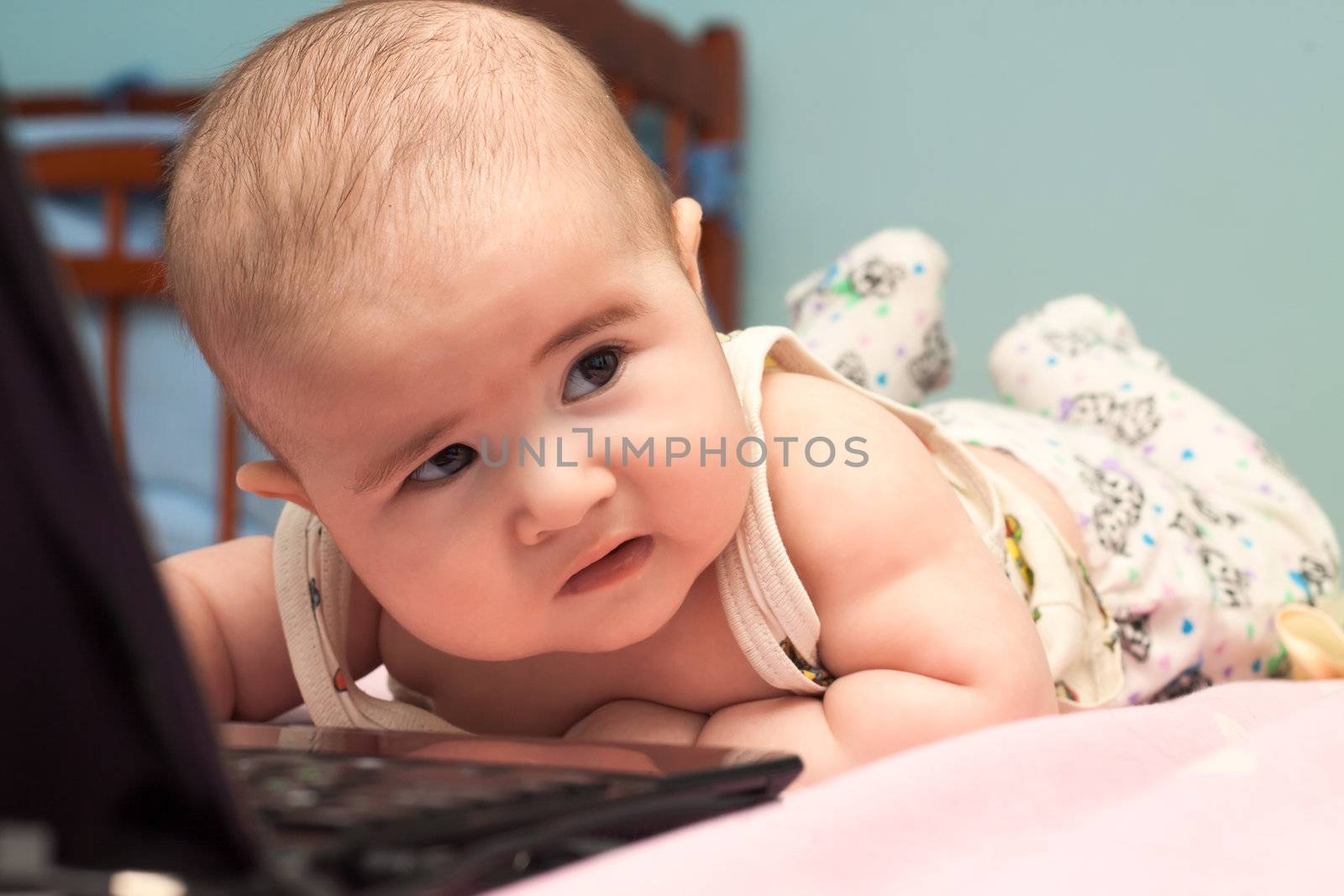 Small child boy using a laptop computer at home