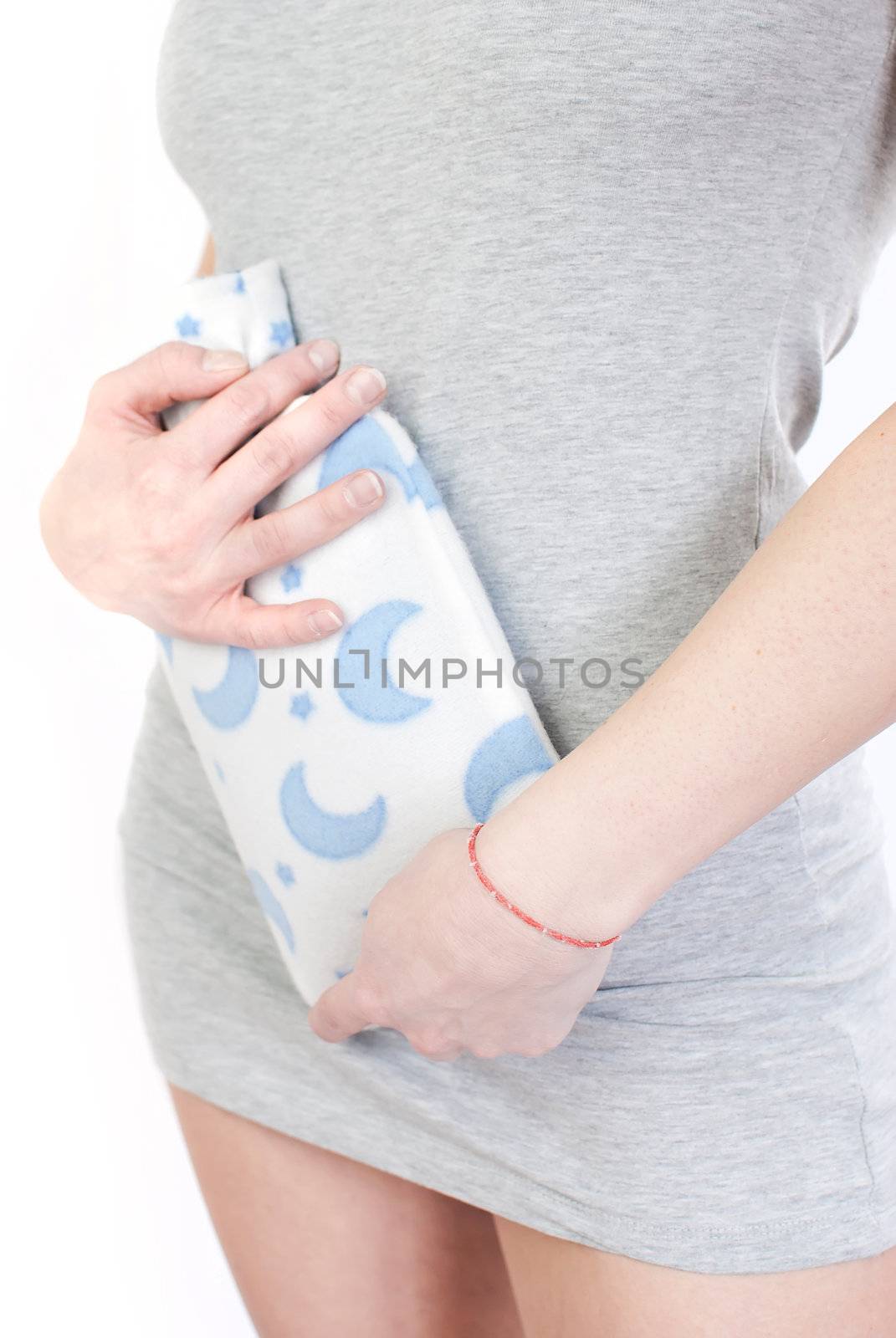 young woman with stomach pain holding hot water bottle