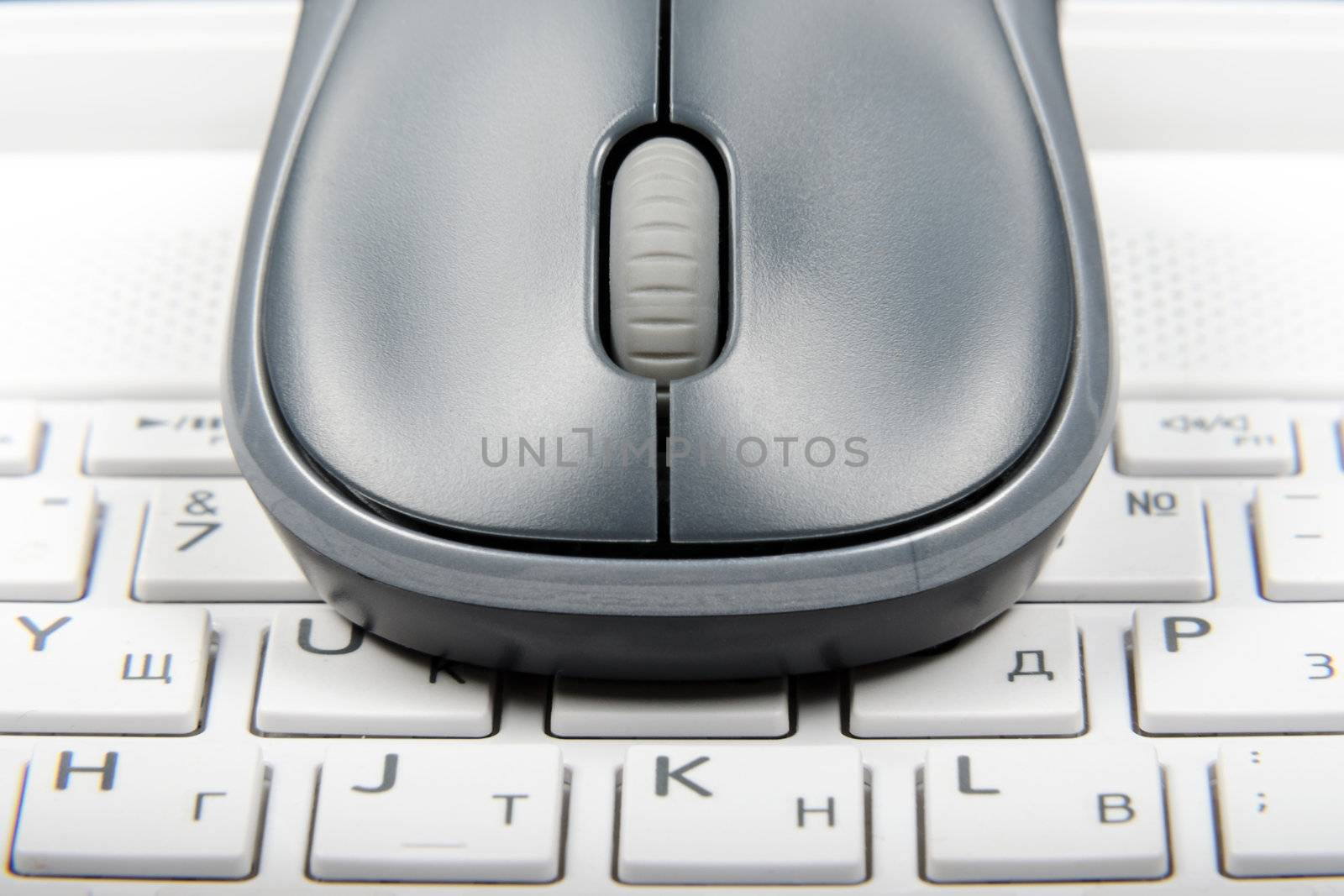 A wireless mouse placed on laptop keyboard