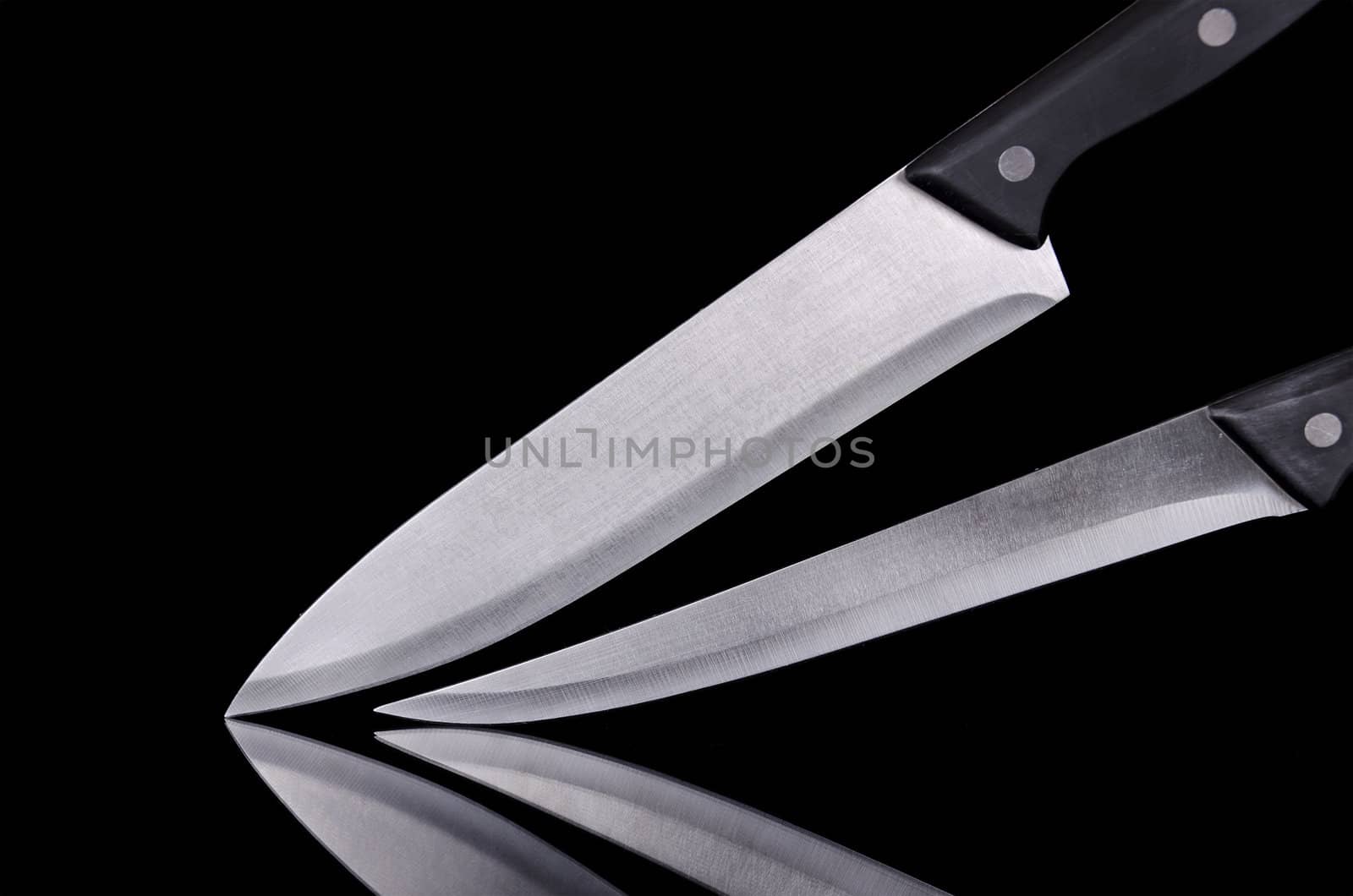 Close up view of two kitchen knives over black isolated background by HERRAEZ